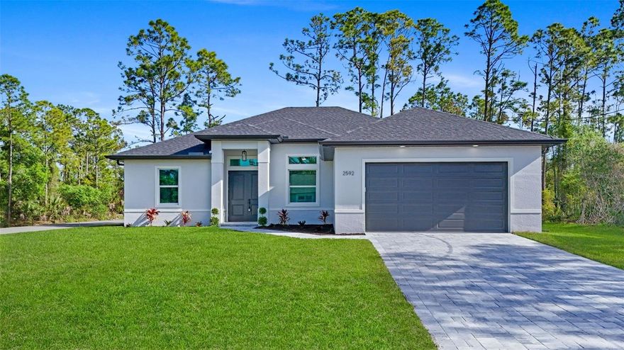 MOVE-IN READY NEW CONSTRUCTION  This home features an OVERSIZED LOT
offering rare one the kind of space which allows for Room for the Pool,  Room for the Boat, Room for the RV. Room to Breathe etc.. Rare oversized lot offering unmatched flexibility — entertain, expand, and enjoy the Florida outdoor lifestyle.
Also features full hurricane-impact windows and doors, an extended oversized garage, and a spacious covered lanai already pre-plumbed for your future outdoor kitchen.  Offering 3 bedrooms, 2 bathrooms, plus a flexible den that can easily function as a 4th bedroom, office, or additional living space, the layout is designed for modern living. As you step inside, you’re welcomed by soaring tray ceilings and expansive 3 panel sliding glass doors that seamlessly connect the interior to the oversized lanai and private backyard — creating an exceptional indoor-outdoor living experience.    At the center of the home is a beautifully appointed chef’s kitchen featuring an impressive 8-foot quartz island, upgraded LG stainless steel appliances, abundant cabinetry, and a spacious breakfast nook — perfect for entertaining or everyday comfort.    The primary suite is a private retreat complete with tray ceilings, a generous walk-in closet, and a spa-inspired bathroom showcasing dual vanities, oversized walk-in showers with glass enclosures, and an expanded layout designed for convenience and relaxation.    Premium Upgrades Include:  Full hurricane-impact windows and doors  Underground utilities for enhanced reliability  Paver driveway with upgraded landscaping  Large covered lanai pre-plumbed for outdoor kitchen  Extended oversized garage ideal for larger vehicles or trucks  Recessed A/C system in garage for climate-controlled storage  Luxury LVP flooring throughout  Glass French doors in the den  Laundry room with built-in cabinetry  Upgraded elongated toilets and Moen Genta fixtures  Nest WiFi smart thermostat for remote climate control, NON Flood Zone lot for added peace of mind