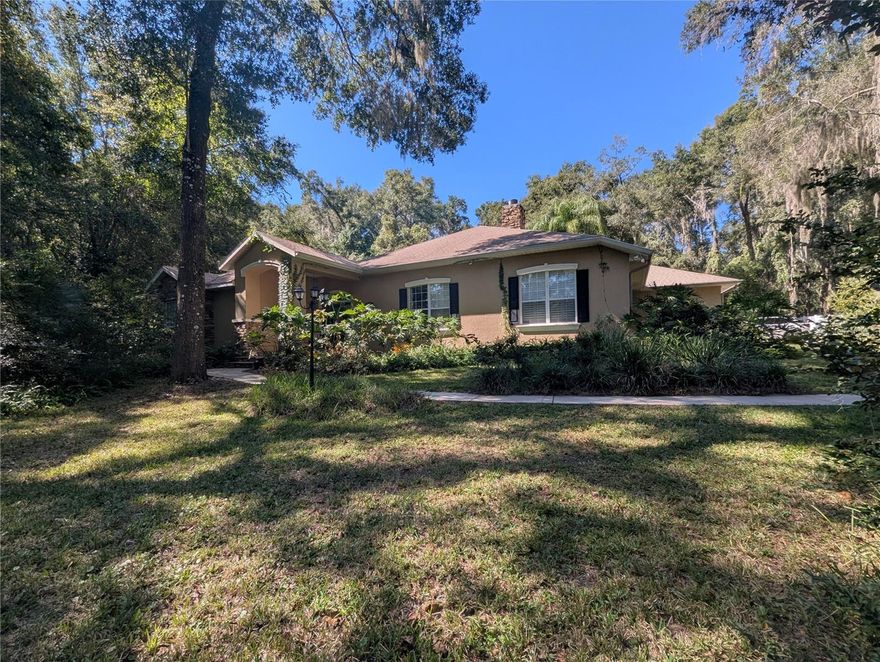 MORE PICTURES COMING SOON! Tucked away in a peaceful, tree-lined neighborhood in Southeast Ocala w/ no HOA, this one-of-a-kind MEDITERRANEAN-STYLE home feels like a hidden oasis — yet it’s just minutes from shopping, dining, and only 7 miles from the WORLD EQUESTRIAN CENTER.

Step through the TILE BREEZEWAY and you’ll be greeted by natural light pouring through ARCHED WINDOWS and FRENCH DOORS, filling each room with warmth and tranquility. Every corner invites you to slow down, breathe, and enjoy the beauty that surrounds you.

At the heart of the property lies a charming COURTYARD GARDEN with BRICK PAVERS that gracefully connects the main home and the PRIVATE IN-LAW SUITE. Stroll along the flower-lined walkway, enjoy your morning coffee among the blooms, or unwind as the evening light filters through the trees.

The TRIPLE SPLIT FLOOR PLAN offers harmony between privacy and connection — featuring an elegant PRIMARY SUITE that opens to the screened LANAI and courtyard, guest rooms tucked quietly away, and the self-contained IN-LAW SUITE ideal for guests or multi-generational living. TILE FLOORS flow throughout, and the KITCHEN is a CHEF’S DREAM with ample counter space, wood cabinets, an ISLAND, EAT-IN AREA, and COUNTER-HEIGHT BAR that opens to the dining room. The cozy, step-down LIVING ROOM features a GAS STONE FIREPLACE and PLANTATION SHUTTERS.

The PRIMARY BATH offers a DUAL-SINK VANITY, WALK-IN SHOWER, LARGE SOAKING TUB, WALK-IN CLOSET, PRIVATE TOILET/WATER CLOSET, and GLASS DOOR with built-in blinds leading to the lanai. The spacious PRIMARY BEDROOM features a TRAY CEILING and DOUBLE SLIDING GLASS DOORS to the lanai and courtyard.

The INSIDE LAUNDRY ROOM provides CABINETS for storage, a FOLDING AREA, and TWO DRYERS and ONE WASHER — perfect for convenience and efficiency.

Outdoors, enjoy your PRIVATE POOL, SPA, and FIREPIT — perfect for Florida evenings under the stars. With over an acre of land, there’s room to garden, entertain, or even keep a horse.

Parking is plentiful with a 2-CAR ATTACHED GARAGE plus a DETACHED 34’x27’ GARAGE with dual electric doors, full RV hookup, and a GENERAC GENERATOR. Recent updates include a 2021 ROOF, new pool salt cell, 2025 A/C control panel, alarm system, and 1,000-gallon underground propane tank.

This is more than a home — it’s a sanctuary where elegance meets comfort, offering space to breathe, room to dream, and a lifestyle you’ll love in the heart of Ocala. Book your private showing today!