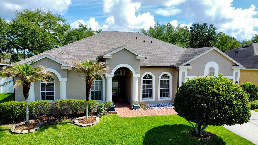 One or more photo(s) has been virtually staged. Welcome to Brookestone, one of Ocoee’s premier gated communities, where comfort, space, and community amenities come together in this spacious single-story 4-bedroom, 3-bath home. Designed with a growing household in mind, the open floor plan offers the flexibility today’s buyers are looking for, with generously sized formal living and dining rooms, a spacious family room, and room for large-scale furnishings throughout.

Warm wood flooring enhances the foyer, formal living room, dining room, dedicated office, and all bedrooms, while tile flooring flows through the kitchen, dinette, and family room for easy everyday living. The kitchen offers solid-surface countertops, stainless-steel appliances, ample cabinet storage, and a newer refrigerator (2019), all opening seamlessly to the dinette and family room—ideal for both everyday living and entertaining.

Natural light fills the home, with sliding glass doors from the formal living room, family room, and primary suite leading to the oversized extended patio, enhanced with tinted sliding casement windows for added comfort and versatility, creating an effortless indoor-outdoor living experience. The fenced backyard offers privacy and plenty of room for pets, play, or future outdoor enjoyment.

The spacious primary suite easily accommodates large furnishings and features a private ensuite bath with double vanities, a soaking tub, a walk-in shower, and direct access to a dedicated office, nursery, or flexible bonus space. A secondary bedroom enjoys near-private bath access, creating an ideal setup for guests or multigenerational living, while the additional bedrooms each include ceiling fans for comfort.

Major updates include roof replacement (2019), HVAC (2014), and water heater (2025) for added peace of mind. Quick closing available, making this an excellent opportunity to be settled before the 2026–2027 school year.

Beyond the home, Brookestone offers an exceptional lifestyle with three gated entrances, a community recreation area featuring a covered gathering pavilion, basketball courts, tennis courts, pickleball, and a large playground. The community also features a solar-powered system that supports the main front gate and common-area lighting, reflecting thoughtful community planning.