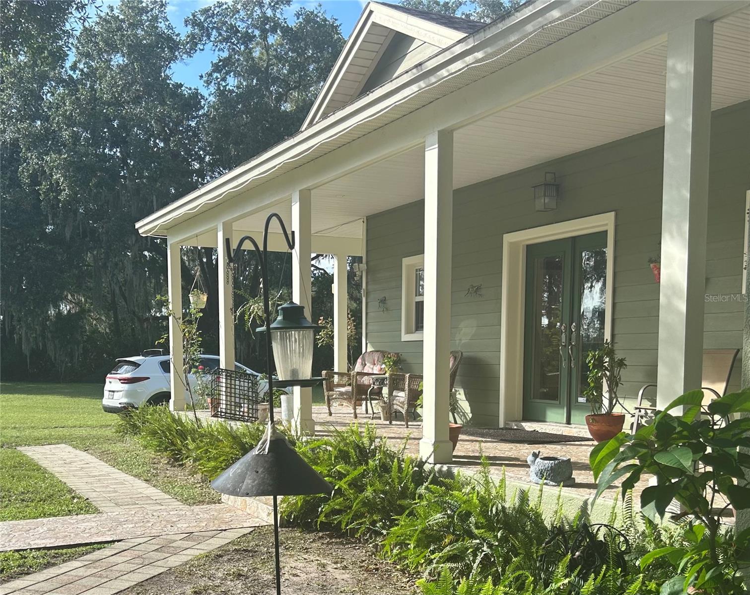 Unique custom built, multifamily 2900 sq. ft. home with two complete kitchens, just under three acres in Land O Lakes, Fl. Rural private setting less than 20 minutes to I-75, 3 minutes to state road 41, an additional 20 to I-275. This is a 4 bedroom, 3 full bath, caged pool home with covered porches front and back. The property is surrounded with mature oaks, fenced, and the Lake borders the entire west side. Large master suite access to front porch, pool deck and office/den which also opens to foyer. Private entrance to 3 of the bedrooms, one bath, kitchen and living area. This area can be used as a private apartment or accessed through living area of house. Large shed with 3 extra rooms can be converted to horse stalls or garage. Concrete half basketball court behind pool and house. Possible one acre split per Pasco County .