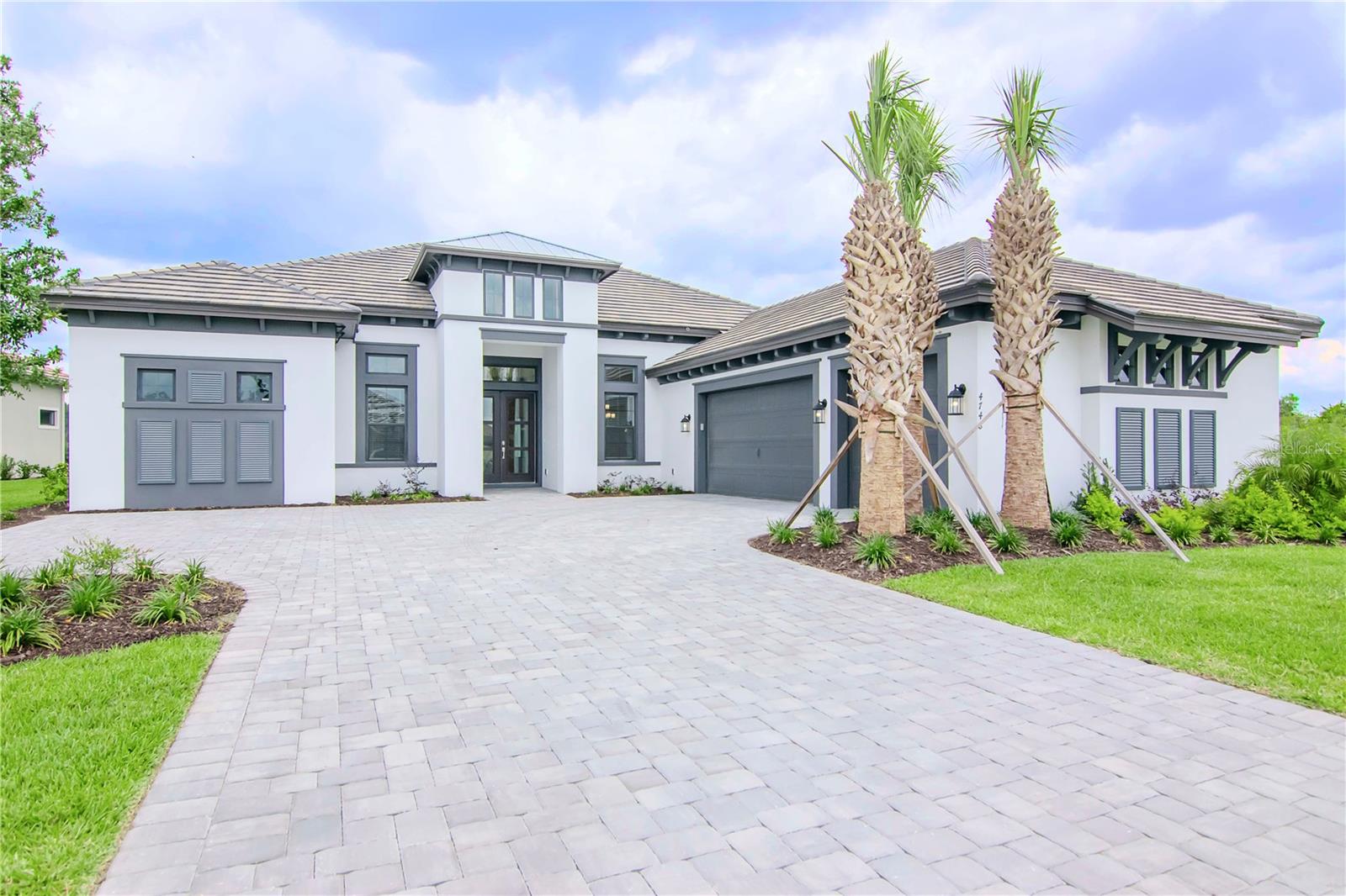 The Beacon is a floor plan that does more than just impress. Located in Wiregrass the heart of Wesley Chapel. This 3,690 square foot home presents three en-suite bedrooms all with walk-in closets, a bonus room, an office and an extra large three-car garage as well as a lineup of distinguished upgrades. When entering through the front door the 14 foot double tray ceilings give an immediate sense of grandeur and spaciousness. The main living area completely opens up, bringing the outside in. The kitchen is stacked with 60+ inch all real wood upper lighted cabinets with glass front doors. The lower cabinets have wooden pull outs and drawers to make access an ease. There is over and under cabinet accent lighting mounted throughout the kitchen. There is eight burner gas range with commercial sized hood, an in-wall oven and microwave, two wine chillers, a huge island with a dishwasher and full size lower cabinets under the breakfast bar. The walk-in pantry is upgraded with wooden shelves. All kitchen appliances are Monogram Cafe Series. The office offers tons of natural light. The back of the property is the bonus room that opens up to the outside as well. This home is an entertainers dream with the heated pool, spa and outdoor kitchen. There is so much to offer in this wonderful, private property.