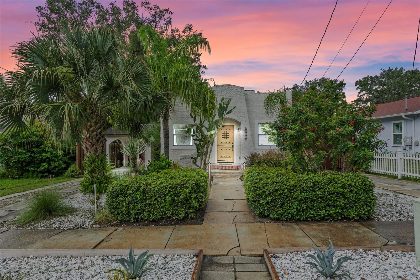 Just six blocks from the heart of downtown Mount Dora, this unique property offers not one, but two beautifully updated homes. The main residence is a charming 3-bedroom, 2-bath featuring a welcoming foyer, a spacious living room with a fireplace flanked by built-in bookshelves, and a remodeled primary suite with dual sinks and a walk-in shower. A formal dining room with built-in china cabinet leads to two additional bedrooms and a guest bath. The kitchen is tastefully finished with granite counters, stainless steel appliances, and modern fixtures, while a Florida room and laundry stretch across the back of the home overlooking the private yard. In 2022, the home received significant updates including new flooring, appliances, plumbing, electrical, and fixtures. The second home is a stylish 1-bedroom, 1-bath with an open floor plan, kitchenette, generous living space, and an oversized closet—perfect for extended family, guests, or rental income. Between the two homes, a newly added screened gazebo with ceiling fan and a fire pit create a tranquil outdoor retreat under a canopy of shade trees. Fully fenced for privacy, this downtown oasis is steps away from Mount Dora’s vibrant restaurants, boutique shops, and year-round festivals, making it an ideal opportunity to enjoy the very best of this beloved lakeside community.