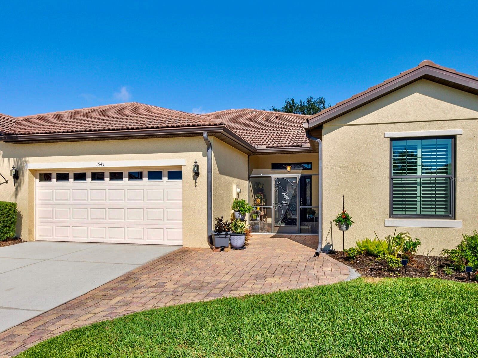 Rarely available spacious Giovanni floor plan! Enjoy lake views from this beautifully upgraded paired-villa in the premier 55+ community of Venetian Falls! Just minutes from sunny beaches, shopping, dining, and Venice’s historic district, this home offers both comfort and peace of mind with so many high-end features. Hurricane-rated, insulated Energy Star impact windows, 20” diagonal porcelain tile and wood laminate floors, a screened and tiled front entry, and an extended lanai create a perfect blend of elegance and functionality. The beveled glass front door welcomes you with abundant natural light. High 9’ ceilings with crown molding, plantation shutters, high baseboards, solar tubes in the living room and primary bathroom, double doors to the den for added privacy, an elegant tray ceiling in the living room, and a central vacuum system elevate the home’s appeal. The kitchen is both stylish and functional, featuring durable quartz countertops, maple-finish cabinetry with trim and under-cabinet lighting, a walk-in pantry, and GE Profile stainless steel appliances, including a convection oven with an induction cooktop. A charming dinette, surrounded by windows, provides a bright and inviting space to enjoy your morning coffee with a view. The open, split floor plan provides flexibility in arranging the common areas to suit your preferences. The den can effortlessly be transformed into a third bedroom. Additional highlights include an expanded paver walkway, in-wall pest control, a leaf guard gutter system, and lush landscaping. For storm protection, easy-to-install hurricane fabric shields are included for the front entry and lanai, plus a reinforced garage door. Step outside to your private outdoor living area, perfect for grilling, dining, and relaxing while taking in serene lake views and the frequent visits from herons and other birds. Venetian Falls offers outstanding amenities, including a resort-style clubhouse with a heated lap pool and spa, a resistance-walking pool, a state-of-the-art fitness center, a billiard room, bocce courts, a full-time activity director, and on-site management. The reasonable HOA fee covers lawn maintenance, irrigation, roof pressure washing, exterior painting, and basic cable TV and internet. Don’t miss this incredible opportunity to enjoy resort-style living in a beautifully maintained home!