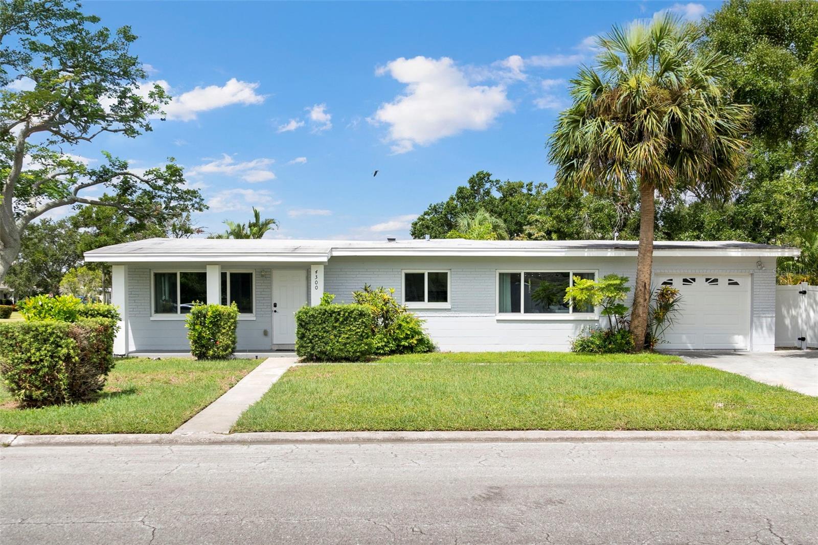 "All the Bells and Whistles" — This beautifully renovated 3-bedroom, 2-bath home with an attached 1-car garage sits proudly on an oversized corner lot in the highly sought-after Snell Shores neighborhood of Northeast St. Petersburg. Step inside to an open, airy floor plan where the living room flows effortlessly into the modern kitchen and dining area. The kitchen shines with crisp white cabinetry, generous counter space, abundant storage, and a sleek stainless-steel appliance package. The desirable split-bedroom layout offers two spacious bedrooms and an updated hall bath with a tub/shower combo on one side of the home. On the other side, a third bedroom with a private en suite bath offers direct access to the backyard and is currently featured as a stylish home office, perfect for remote work or guests. Out back the fully fenced yard offers endless possibilities — add a pool, create a lush garden oasis, or even build an accessory dwelling unit (ADU). The oversized lot provides room to dream. Notable updates include hurricane-impact windows, a zone-controlled ductless AC system, and peace of mind knowing this property has had no flooding water intrusion from either Milton or Helene. Enjoy the unbeatable location with Whole Foods, Publix, Trader Joe’s, and Fresh Market just minutes away, along with a variety of restaurants, gyms, and coffee shops along the vibrant 4th Street N corridor. Downtown St. Pete is less than 15 minutes, and Tampa International Airport is under 30 minutes away.