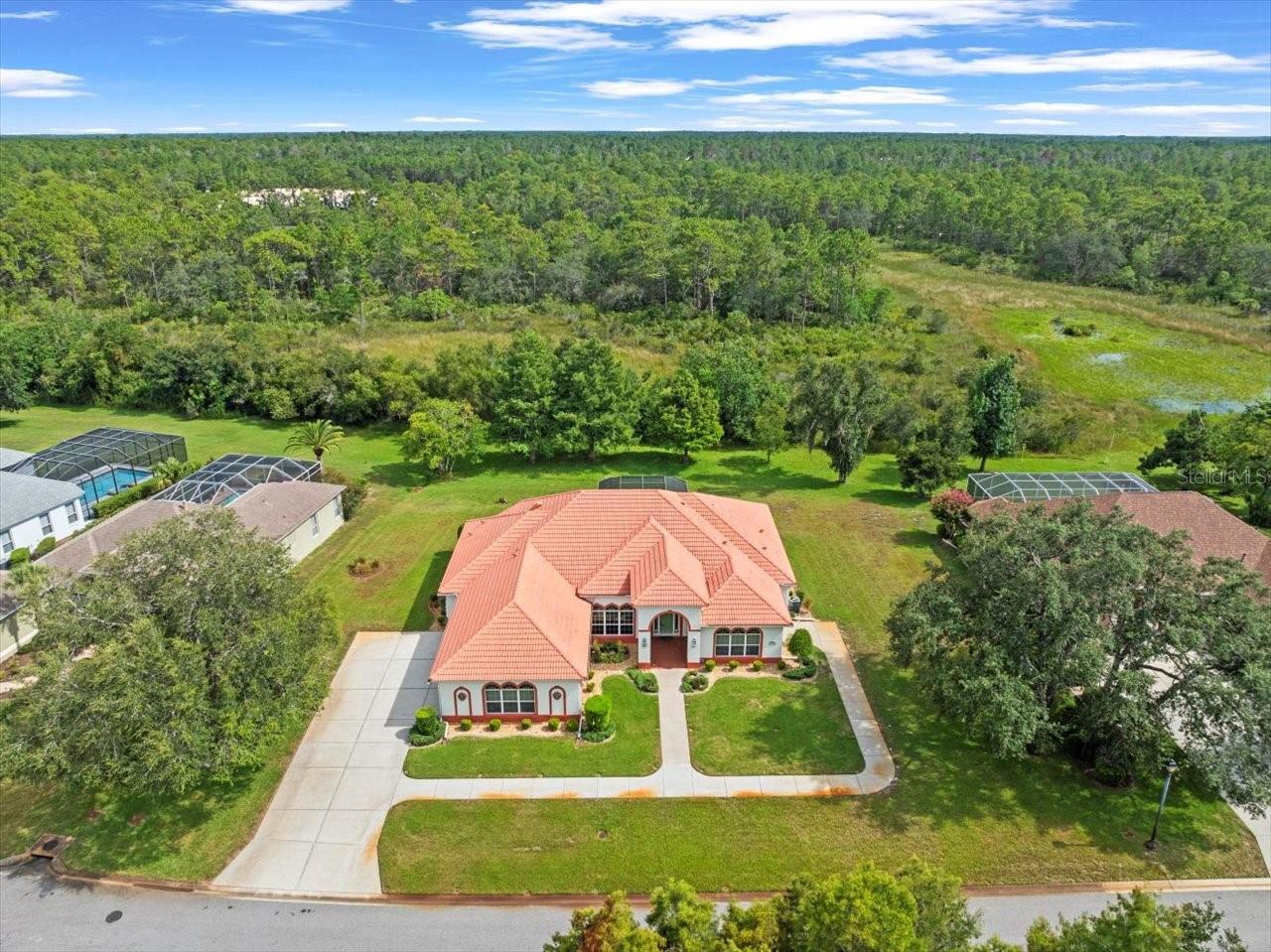 Located in Glen Lakes, this impeccably maintained 2000 built Addison Custom home is located on a double lot (.7 acre) and is situated on a peaceful homesite. 3 bedrooms/2.5 baths/3 car+golf cart garage with all having power screens. Large driveway for parking convenience. Tile roof, beautiful landscaping with stone beds and Curb-a-Lawn, twin A/Cs, water softener, irrigation well, storm shutters, double pane windows. Large screened lanai and patio with pavers. Enter this home via a spacious foyer with pillars, great room with triple sliders to the patio and formal dining room, split bedroom plan, arched doorways with frame molding, high flat 10 ft. and 12 ft. ceilings, crown molding, tile and hardwood flooring, all bedrooms have walk-in California closets, luxury blinds throughout, 14 ft. x 16 ft. breakfast area with double sliders to the patio, kitchen with center island, breakfast bar, stainless steel appliances, Corian countertops. Primary suite with tray ceiling, sitting area, sliders to the patio. Primary bath with jetted tub and separate shower, twin sinks, Corian counters. Bedrooms 2 and 3 have a Jack-and-Jill bath with twin sinks. Laundry room has washer and dryer and sink with cabinets. 2707 living sq. ft., 4421 total sq. ft. HOA FEES INCLUDE CABLE AND HIGH SPEED INTERNET AND PRIVATE MAINTAINED STREETS, 24 HOUR SECURITY WITH MANNED GATE. Glen Lakes is a wonderful gated and manned golf course community and surrounded by the 85,000 acre Chassahowitzka National Wildlife Refuge. The required social membership gives access to the clubhouse, restaurant, bar, Jr. Olympic size heated pool/spa, fitness center, clay tennis courts, pickleball courts and a vast array of social clubs. Golf memberships also available.