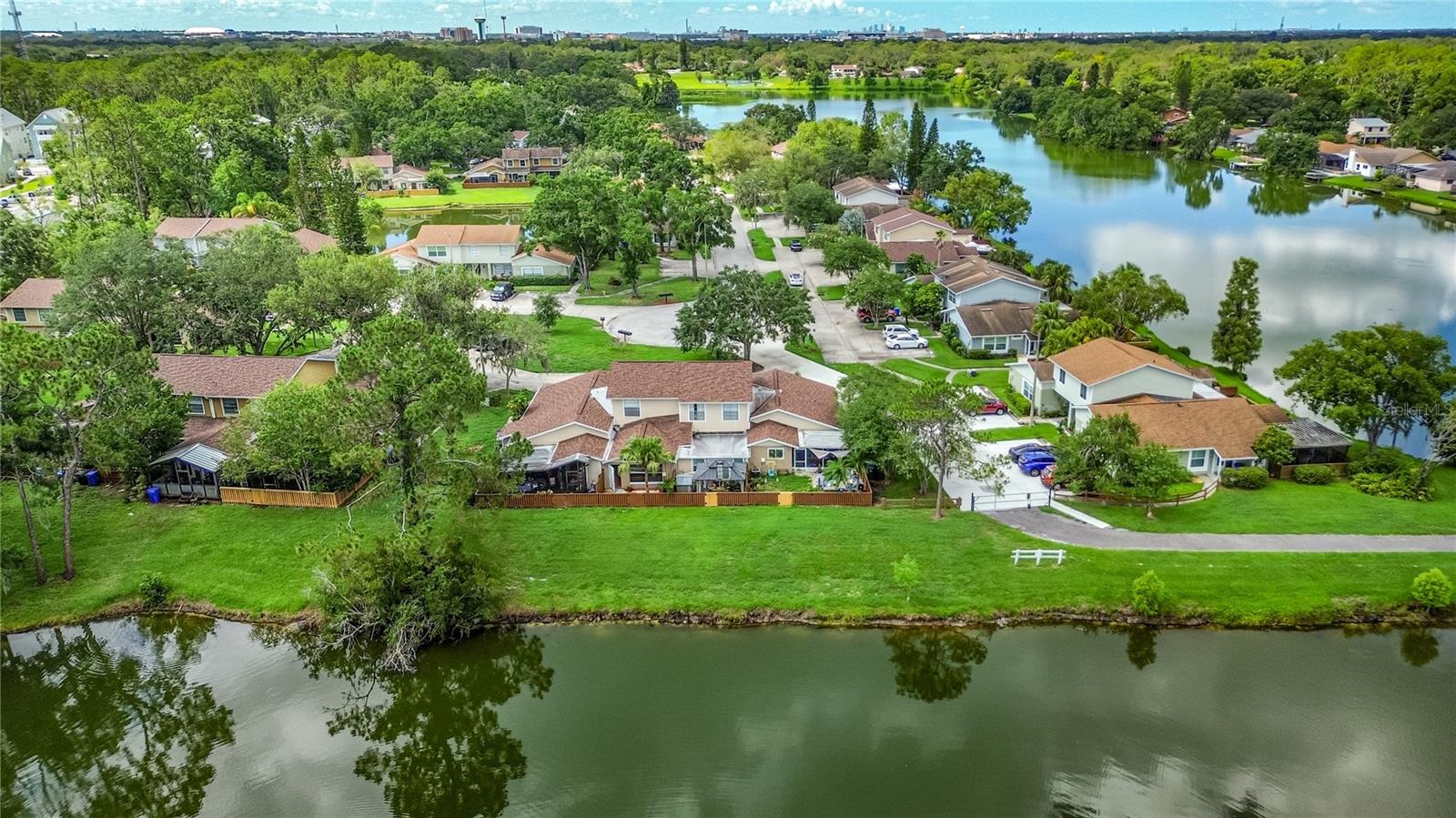 One or more photo(s) has been virtually staged. One or more photo(s) has been virtually staged. Enjoy the serenity of a lakefront home with serene water views from the bedroom, living room and fenced back yard. Nestled in a park like setting the end of a cul-de-sac, this home is a quick drive to USF, Moffitt Cancer Center and many of the local research hospitals as well as convenient to shopping, restaurants and local activities. This 2 bedroom 2 bath home is in a POOL COMMUNITY with TENNIS COURTS, PICKLEBALL COURTS and WALKING TRAILS. The kitchen features granite counters and solid wood cabinets. New stainless steel appliances are being installed on July 23. Soaring ceilings give the living room a majestic feel. Hardwood floors add that touch of class. There are not many homes available in such a great, parklike setting at this price. THE AC was REPLACED in2025 which will help with your electric bills