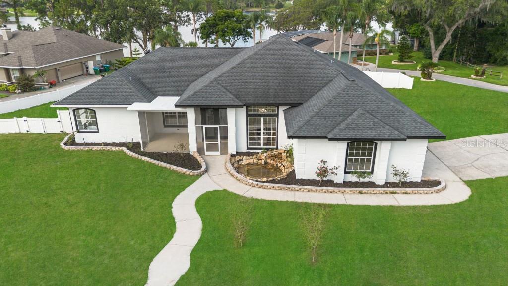 Welcome to 1148 Rosetta Drive E – Your Private Lakefront Oasis! WOW… this is the one you’ve been waiting for! Perfectly situated with serene views of Lake McGarity, this fully renovated home is a rare blend of luxury, comfort, and modern design—ideal for entertaining or simply living your best life. Step through the custom glass-etched front door and into an expansive open floor plan that seamlessly connects the foyer, great room, formal dining area, and an absolutely stunning kitchen. The chef’s kitchen is a showpiece, featuring quartz countertops, stainless steel appliances, modern cabinetry, designer backsplash, a walk-in pantry, and ample storage for all your culinary needs. The primary suite is a true retreat, offering private access to the pool, a spacious walk-in closet, and a spa-inspired ensuite bathroom with a soaking tub, walk-in shower, and dual vanities—all finished with premium materials and elegant touches. Two additional bedrooms are generously sized, offering comfort and flexibility for guests, family, or a home office. Four sliding glass doors open to the impressive outdoor living area—blurring the line between indoor and outdoor space. Enjoy year-round relaxation in the screened-in lagoon-style pool, complete with a large covered lanai perfect for entertaining. Newer roof, newer HVAC, and new water heater, providing peace of mind and energy efficiency. Homes with this level of modernization and this location are incredibly rare. Don’t miss your opportunity to own a slice of paradise—1148 Rosetta Drive E won’t last long!