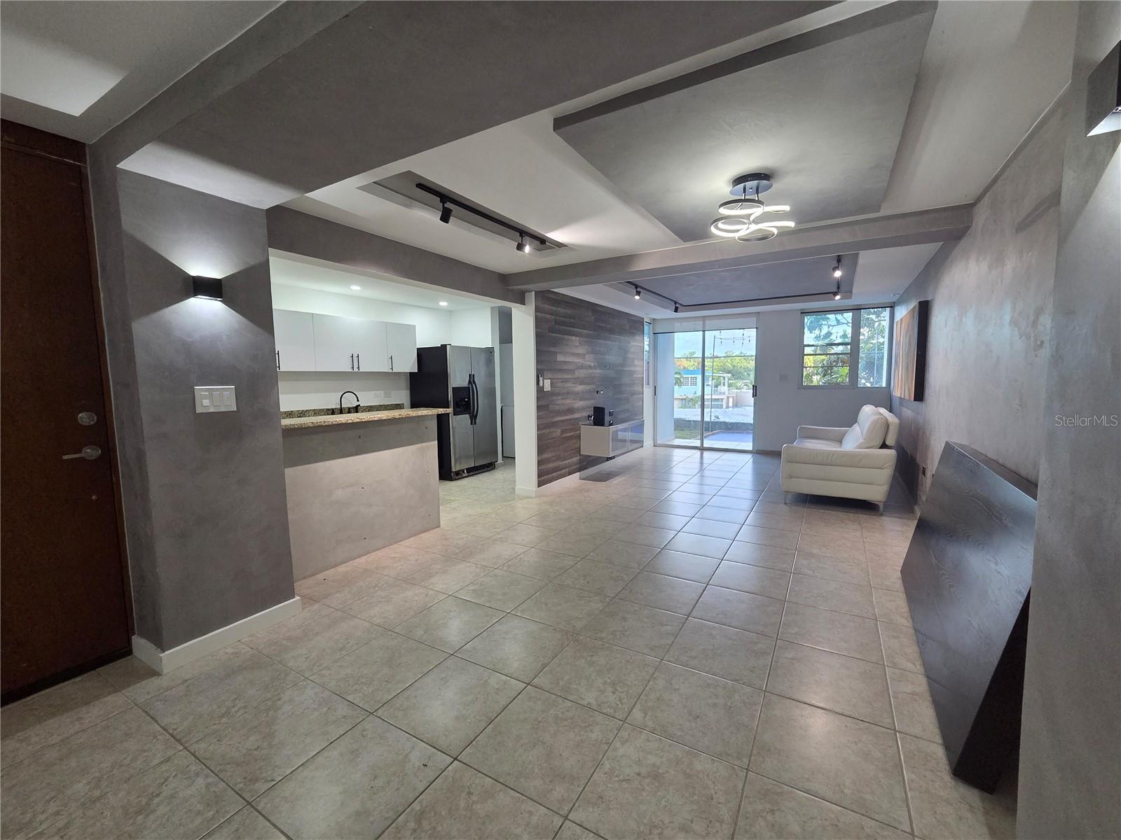 Spacious walk-up apartment on the first floor, down stairs, with open layout, security and access control. Freshly painted, ready to move in. 3 bedrooms, 2 bathrooms, living room, dining room, kitchen, laundry room, large patio and 2 parking spaces. Various gypsum board fascia and exposed cement walls make the apartment unique. Excellent complex with pool and gazebo. Includes: refrigerator, stove, washer and dryer combo, 1 A/C. Prime location near 65th Infantry, Route 66, Plaza Carolina, Plaza Escorial, schools and universities, several supermarkets, pharmacies and more.