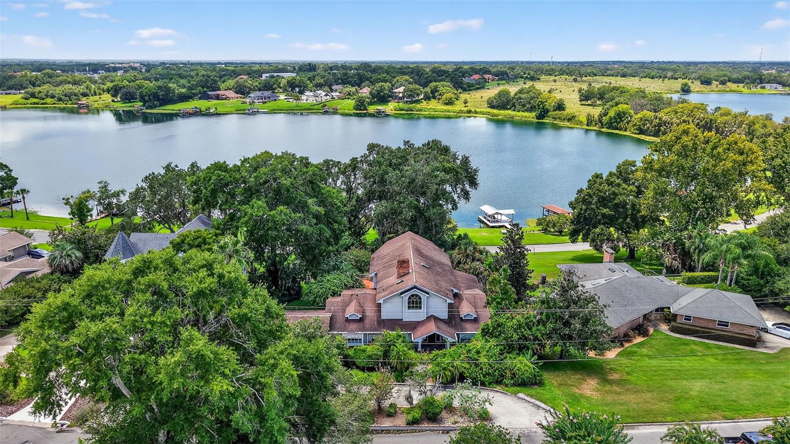 LAKEFRONT LIVING AT ITS FINEST ON EAST CROOKED LAKE! Welcome to 2450 Topping Place, a one-of-a-kind 4-bedroom, 3-bathroom lakefront retreat nestled on the sparkling shores of East Crooked Lake—one of Central Florida’s most pristine and spring-fed lakes. Situated on just over half an acre, this charming and character-rich home offers breathtaking water views, endless recreational opportunities, and a peaceful lifestyle just minutes from vibrant downtown Eustis and the historic streets of Mount Dora. Step inside to a light-filled haven featuring expansive windows that frame stunning lake vistas from nearly every room. With real hardwood floors, two fireplaces (including one in the primary suite), vaulted cathedral ceilings, and intricate wood trim, this home exudes warmth and timeless craftsmanship. The spacious primary suite is a true retreat, complete with cedar-lined closets, a jetted soaking tub, and even a loft space that overlooks the great room—perfect for a private reading nook or creative escape. Love the outdoors? Your private deck and brand-new floating boat dock (with a lifetime warranty) offer direct access to boating, paddleboarding, waterskiing, or simply relaxing under the Florida sun. Mature trees and refreshed landscaping create a serene, park-like setting, and the circular driveway adds convenience and curb appeal. This home has undergone extensive updates for modern comfort and peace of mind, including three brand-new A/C units with new thermostats, all-new electrical wiring and panel, new plumbing throughout, two tankless water heaters, updated LED lighting and ceiling fans, new appliances, a new deck and sprinkler system, ADT alarm system, and a new garage door—just to name a few. Located just minutes from local favorites like Ferran Park, Lake Eustis waterfront dining, and the boutique shops and events of downtown Mount Dora, this home offers the ideal blend of lakeside serenity and community charm. Don’t miss your chance to own this slice of waterfront paradise with unlimited potential. Schedule your private showing today!