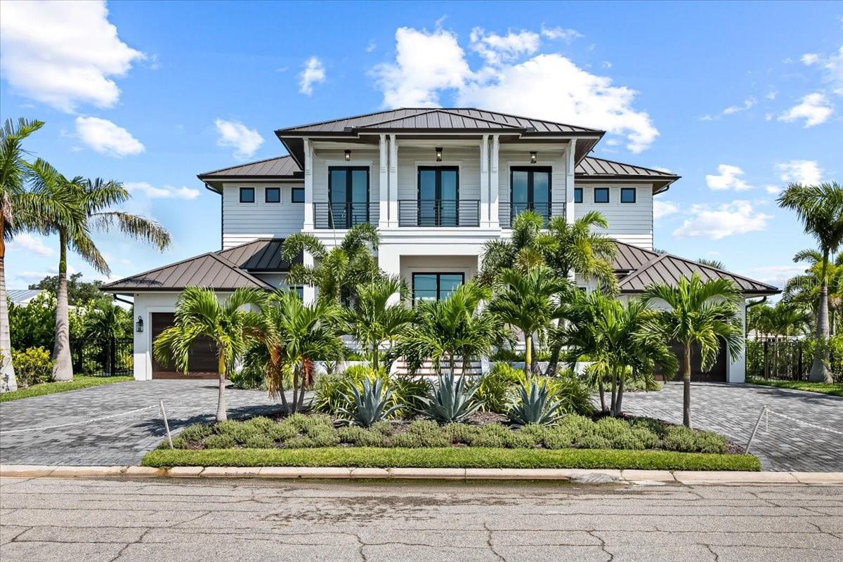 Brand New!!! Custom Coastal Elegant Home, ready to call your own. No waiting to build, no waiting to remodel. Your new home was custom built with all luxuries you wanted and more. This home was built on the Grand Canal, the largest canal on Anna Maria Island. The outside living is an oasis, consisting of multiple sitting areas, equipped with gas fireplaces, an electric screen, an infinity, heated, saltwater pool and spa, which leads to 90' of water frontage and a 65' long dock with a 13000 # electric lift. The first-floor office leads to an outdoor space that is covered by an electric pergola. There is even an outdoor heated shower to wash the salt water off. After watching the beautiful sunset, walk back inside through your oversize 3 panel sliding doors to your chef's kitchen where you can easily whip up dinner on your Wolf oven. The kitchen has a designer aluminum hood, a walk-in pantry, a super large quartz countertop that seats six, comfortably and plenty of storage with the custom cabinetry. The master bedroom is on the first floor with views of the water, and a gorgeous master bath with a tub. The master bedroom leads to a walk-in closet and laundry room. The entire house has architectural lighting throughout including several chandeliers. On the second floor, there is 5 en suite bedrooms; all with double shower heads, including an oversized rain shower and back lighting. The main living room, the master bedroom and both bedrooms on the second floor facing the water, have remote controlled shades floor to cover the floor to ceiling windows. There is an elevator for convenience, just drive into the garage, open the house door, and the entrance to the elevator is right there available from the bottom to the top floor. On the second floor there is another stunning deck overlooking the pool and canal. Also, on the second floor is a media room with a wet bar. There is a second laundry room on the second floor, a well. There is extensive lighted landscaping as well. There is a circular drive with easy access to both garages and plenty of parking. There is 2 HVAC units to control the 2 zoned systems, one for the first floor and one for the second floor. The fence surrounding the property is aluminum. There is speaker system in and outside the home. This is a smart home in that most of the home can be controlled from your cell phone. Your new coastal custom home is waiting. ** NO water intrusion during the storm surge of Idalia. You will notice the home is built on a grated lot for additional protection. Rest Assured High and Dry. Wine Rack done 11/23. Outdoor kitchen will be finished 1/2024. New Trex dock 1/2024.