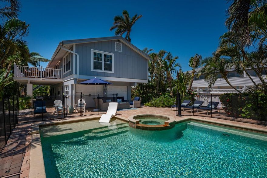 Discover your own tropical paradise on the serene North end of Longboat Key and has deeded beach access, a rare gem that blends privacy, luxury, and coastal charm. This stunning, fully renovated home boasts a thoughtfully designed open split-floor plan, perfect for relaxed living and entertaining. The custom-designed kitchen is a chef's dream, featuring sleek solid countertops, custom cabinetry, and premium stainless-steel appliances. An expansive island bar creates an inviting space for casual dining and social gatherings. Gorgeous, engineered wood floors flow throughout the main living areas, adding warmth and elegance. The spacious master suite offers a tranquil retreat, complete with a newly remodeled spa-like master bath ideal for unwinding after a day spent on the water. A well-appointed guest bedroom with its own private bath ensures comfort and privacy for visitors. Step outside to your private oasis, where a sprawling rear balcony overlooks serene canal views and the heated pool. The expansive paver deck offers ample space for lounging, dining, and soaking up the Florida sun. Boating enthusiasts will be delighted by the 120-foot seawall, 7,000 lb. boat lift, and convenient docking and mooring features providing effortless access to the open water. This property is designed with both style and security in mind. The durable standing seam metal roof and hurricane-resistant impact glass windows and doors provide peace of mind during storm season. The lower level features a versatile guest or in-law suite complete with an upgraded bathroom and kitchenette, ideal for hosting family or accommodating extended stays. Lush, meticulously maintained landscaping showcases a variety of palm trees and fruit trees, creating a true tropical escape. The two-car garage, finished with a sleek and durable epoxy coating, combines style with functionality.