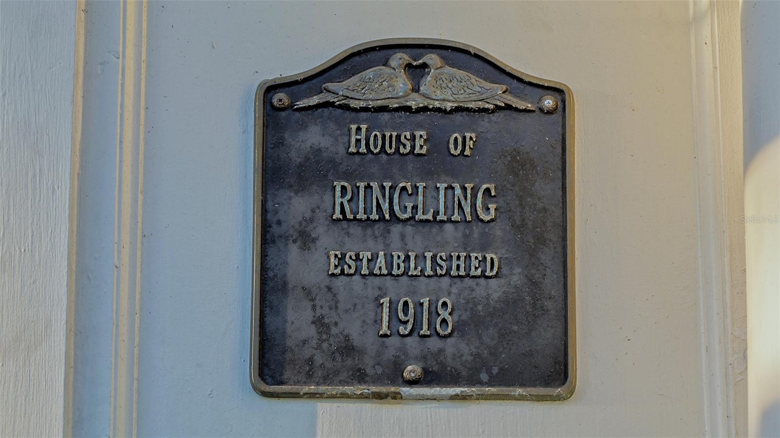 Step into history and timeless elegance at the House of Ringling, a landmark estate in Sarasota's coveted Whitfield Estates, built in 1918 for Alfred Ringling of the legendary Ringling Brothers. Spanning 4,782+/- sq. ft., this 5BR, 4.5BA masterpiece seamlessly marries Gilded Age opulence with modern luxury. A red brick walkway and expansive front lawn welcome you to this architectural treasure, where an oversized Grand Ballroom with a 21-foot ceiling, Venetian columns and a Renaissance-style coffered ceiling create an awe-inspiring focal point. Original pine floors, 12-inch baseboards and hand-poured antique glass in French windows and doors preserve the estate’s rich craftsmanship, as the reimagined chef’s kitchen is a showpiece, featuring Big Chill appliances, an 8-burner gas stove, Quartzite surfaces, a mother-of-pearl backsplash and backlit cabinets. The primary suite on the lower level offers floor-to-ceiling French doors opening to a private porch and the expansive pool deck. Upstairs, 2 ensuite bedrooms feature partial bay views. Hidden details, including a prohibition-era speakeasy/3rd bedroom at the top of the stairs and a secret room, add intrigue and charm. The home’s walls, crafted from Ringling railway car paneling, echo its storied past. Recent updates, including new plumbing, electrical, HVAC (5 units), and a new roof with extra tie-down straps, ensure modern comfort while preserving historic character. A detached 2-car garage and 2 driveways provide ample space, while the expansive Palm Beach-style courtyard invites relaxation. As one of the first Ringling Brothers homes in Sarasota, this estate offers a rare opportunity to own a living piece of history in a prime location near Sarasota Bay and downtown.