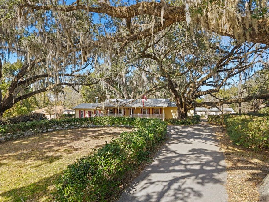 Standing on a hill shaded by massive live oaks, this five bedroom three and a half bath property was built for gracious living. With nearly two acres, the large lot holds a three bedroom two bath main house, a two bedroom one bath guest house, an in-ground swimming pool with a cabana and half bathroom, a pole barn, and two storage buildings. Coming up the horseshoe driveway, you will immediately appreciate the serene setting created by mature landscaping, ancient moss draped oaks, and sprawling covered front porch. From the front door, a welcoming formal living and dining room opens to a huge family room with a beautiful free standing wood burning fireplace and French doors leading to an open patio surrounded by lush landscaping. The kitchen is the heart of the home with peaceful back yard views. A spacious primary suite includes an oversized spa-like bathroom with a large walk-in shower and a stunning bay window. Two more comfortable bedrooms and a full bathroom complete the main house. From the patio, a winding walk way takes you past the swimming pool to a charming two bedroom guest house complete with a full kitchen and living room, its own laundry room and outside shower! Every weekend is a holiday when spent at the sparkling swimming pool and cabana. Your RV and boats will be safely out of the weather in the three bay pole barn, and there’s no shortage of space in the two storage buildings. Williston is a friendly community with multiple shopping and dining options. Known as the Gateway to the Nature Coast, there is convenient access to various rivers and lakes, the Gulf, and world class scuba diving at nearby Devil’s Den and Blue Grotto. The World Equestrian Center and Florida’s horse country is less than thirty minutes away. A twenty minute drive brings you to Gainesville with endless shopping and dining opportunities, North Florida Regional, VA, and Shands hospitals, Santa Fe College, and the University of Florida! Call today to see this amazing property for yourself.