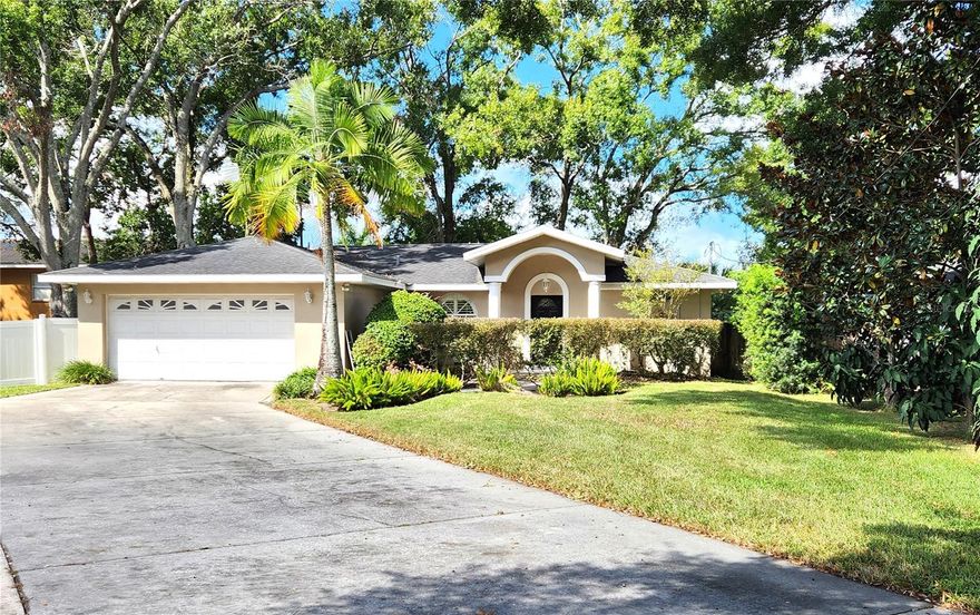 This beautifully updated 2-bedroom, 2-bathroom, 2-car garage home is situated on nearly ¼ acre in a quiet, centrally located Tampa neighborhood. From the moment you arrive, you’ll notice the professionally designed shrubbery and expanded driveway, offering ample parking for guests or multiple vehicles. Step inside to an open-concept floor plan featuring a spacious living and dining area with custom plantation shutters, perfect for both everyday living and entertaining. The kitchen is a true highlight, boasting granite countertops, stainless steel appliances, an island sink with breakfast bar, and ample cabinet space. The split floor plan provides privacy, with the primary suite featuring a walk-in closet and a stylish en-suite bathroom complete with granite vanity and walk-in shower. The second bedroom is tucked away for added privacy, and the guest bathroom has been tastefully updated with new luxury vinyl plank flooring and a tub/shower combo. Enjoy Florida living year-round in the screened and covered lanai, which leads out to a large wooden deck—ideal for grilling, relaxing, or entertaining. The fenced backyard is expansive, offering plenty of room for pets, kids, or even a pool. The home features and new AC System. The home had a small settlement issue that was documented and professionally remediated in 2025 for peace of mind. The home’s prime location just off Dale Mabry Hwy and Water Ave offer easy access to shopping, dining, downtown Tampa, and major highways. This home offers comfort, style, and convenience — all on a generous lot in a desirable location. Don’t miss out on this Tampa gem!