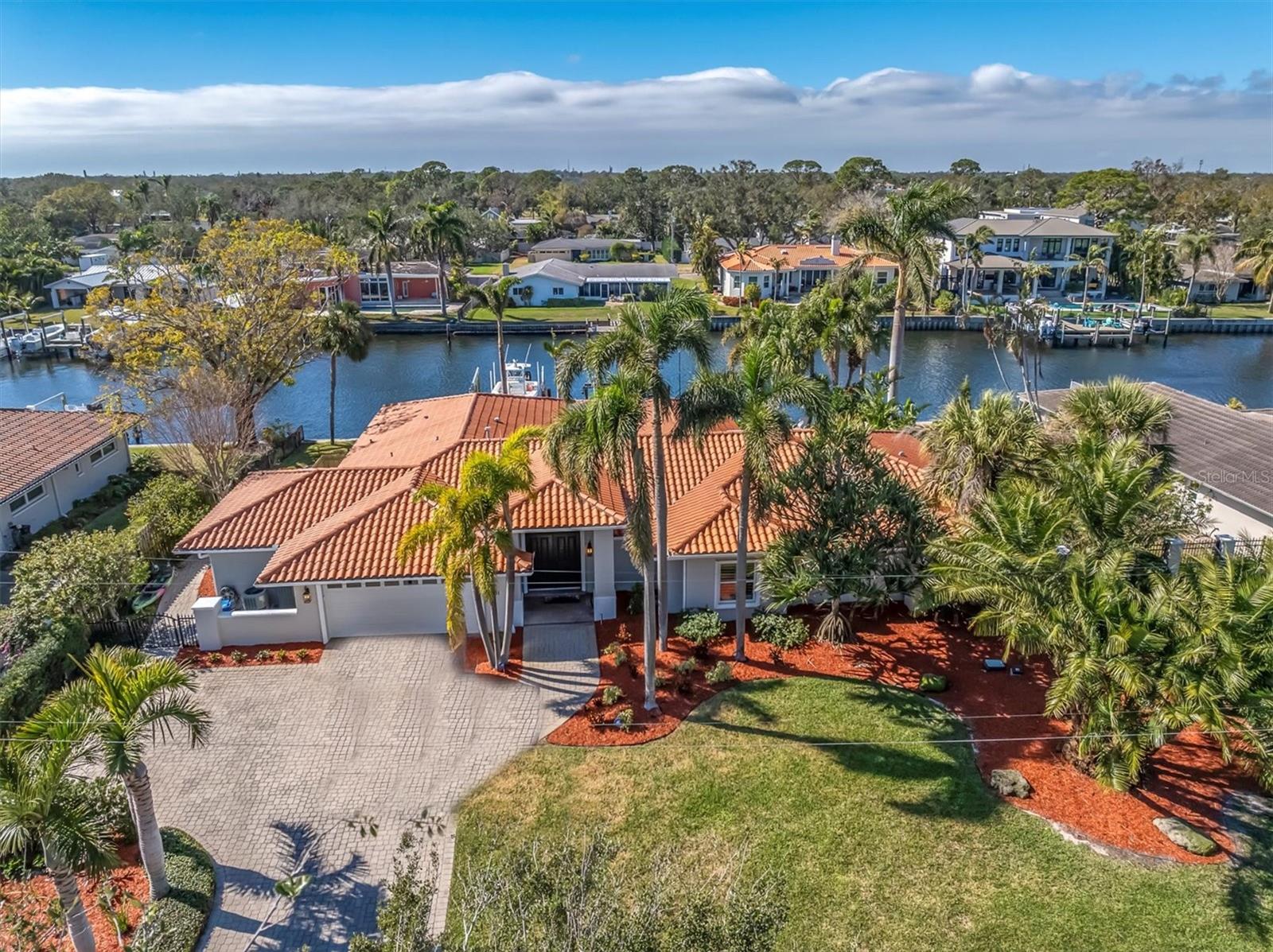 Welcome to your stunning and luxurious executive waterfront retreat in the prestigious Snell Isle Estates neighborhood of St. Petersburg. This meticulously designed 5 bedroom, 3 bathroom waterfront estate which was completely rebuilt by Lux Associates Architects in 2000, offers 3,330 square feet of living space, seamlessly blending modern elegance with coastal charm in an opulent single-story residence that has never flooded. Step inside to discover an entertainer's dream with a bright, inviting open floor plan adorned with limestone tile flooring throughout most living areas and plush carpeting in the bedrooms. The chef's kitchen is a culinary masterpiece, featuring a Thermador gas cooktop, exhaust vent, granite countertops, Kitchenaid dishwasher, KitchenAid double oven, built-in KitchenAid refrigerator, large basin sink with disposal, and a spacious island with an additional basin sink, disposal, and water filtration system. Adjacent to the kitchen, the expansive butler's pantry offers a second dishwasher, standalone ice maker, basin sink with disposal, and abundant cabinetry for extra storage. Relax and unwind in the spacious owner's suite, an oasis featuring sliding doors to the pool and a large custom walk-in closet with built-in shelving and a central island. The luxurious en-suite bathroom, finished in limestone, pampers you with dual vanities, a garden tub, a glass-walled walk-in shower, and a private water closet. Enjoy the best of outdoor living with a heated saltwater pool, beautifully paved patio, and a convenient outdoor shower. Boating and fishing enthusiasts will appreciate the newer 20,000 lb boat lift with six pylons, a concrete seawall, and a fish cleaning station—providing seamless access to Tampa Bay and the Gulf of America. Additional highlights include an oversized 2-car garage with an opener, a whole-house security system, an in-wall termite treatment system with a warranty, and thoughtful design features throughout.Nestled between the Vinoy Golf Course and Smacks Bayou, this home is located in one of St. Petersburg’s most sought-after neighborhoods and school zones.Don't miss your chance to own this exceptional waterfront property that encapsulates the very best of Florida living. Schedule a private tour today!
