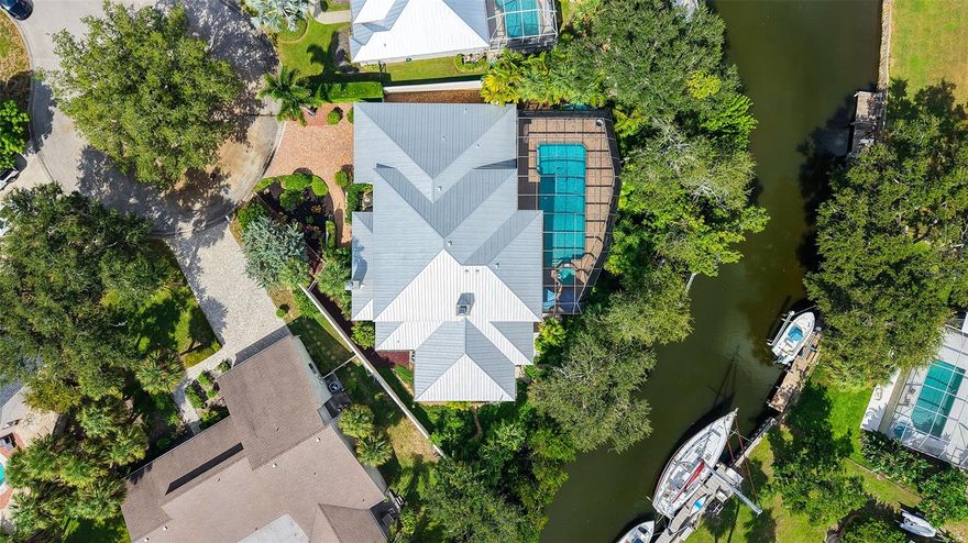 Waterfront Luxury Living at its Finest! Enjoy direct boat access to Gulf through Midnight Pass with no bridges to navigate under.  This stunning canal-front estate offers the perfect blend of elegance, comfort, and functionality, all just minutes from Siesta Key and the best of Sarasota living. A private iron gate and paver driveway lead to a secluded courtyard, setting the tone for the luxurious living that awaits inside. Upon entering through etched glass double doors, you're greeted by soaring tray ceilings, custom architectural details, and a spacious open floor plan designed for both everyday relaxation and seamless entertainment. The great room is anchored by a striking European-style carved wood fireplace with a wine-making motif, creating a cozy focal point. Adjacent to the living area, the gourmet kitchen is a chef’s dream, featuring solid wood cabinetry, a copper sink, and a large granite bar with seating for six, plus an induction cooktop and separate oven. A butler’s pantry and an eat-in area overlooking the pool add convenience and charm. For more formal occasions, the dining room provides a view of the private courtyard. Designed with privacy in mind, the home boasts a split-floor plan, including a spacious owner’s suite with a newly renovated spa-inspired bathroom, complete with a custom tile walk-in shower, soaking tub, dual sinks with granite countertops, and built-in cabinetry. The walk-in closet offers custom organization, and the suite has direct access to the pool area through sliding glass doors. The second bedroom is handicap accessible with its own ensuite bathroom and pool access, while the third bedroom, currently used as a den, offers a Murphy bed and its own ensuite bathroom. The expansive living space extends outdoors through French doors leading to the oversized pool and spa, surrounded by lush tropical landscaping and offering stunning water views.  A boater’s paradise, the private 65’ dock has room for two vessels with one in the 13,000 lb. lift and space for another boat or yacht along the dock, complete with shore power, freshwater, and night lighting.  The canal has direct access to the Intracoastal Waterway.  Additional features include tile and engineered hardwood floors, a large two-car garage with built-in storage, updated AC units, a new metal roof (2023), dual tankless water heaters, and modern pool equipment. This property is fully equipped with outdoor electrical, irrigation, and a dog run with fencing, ensuring comfort and convenience for all. Located in a coveted West of Trail neighborhood, this home offers unparalleled proximity to Siesta Key, Gulf Gate dining and shopping, and downtown Sarasota and Venice.  This home sits on high ground and has never sustained any storm damage or flooding. Flood map indicates a 1% flood risk; owner is not required to carry flood insurance. This one-of-a-kind property truly offers the best of waterfront living—don’t miss the opportunity to make it yours!
