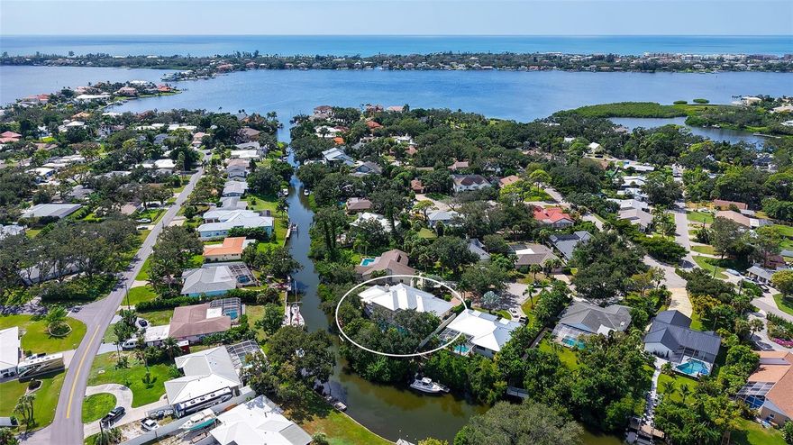 Waterfront Luxury Living at its Finest! Enjoy direct boat access to Gulf through Midnight Pass with no bridges to navigate under.  This stunning canal-front estate offers the perfect blend of elegance, comfort, and functionality, all just minutes from Siesta Key and the best of Sarasota living. A private iron gate and paver driveway lead to a secluded courtyard, setting the tone for the luxurious living that awaits inside. Upon entering through etched glass double doors, you're greeted by soaring tray ceilings, custom architectural details, and a spacious open floor plan designed for both everyday relaxation and seamless entertainment. The great room is anchored by a striking European-style carved wood fireplace with a wine-making motif, creating a cozy focal point. Adjacent to the living area, the gourmet kitchen is a chef’s dream, featuring solid wood cabinetry, a copper sink, and a large granite bar with seating for six, plus an induction cooktop and separate oven. A butler’s pantry and an eat-in area overlooking the pool add convenience and charm. For more formal occasions, the dining room provides a view of the private courtyard. Designed with privacy in mind, the home boasts a split-floor plan, including a spacious owner’s suite with a newly renovated spa-inspired bathroom, complete with a custom tile walk-in shower, soaking tub, dual sinks with granite countertops, and built-in cabinetry. The walk-in closet offers custom organization, and the suite has direct access to the pool area through sliding glass doors. The second bedroom is handicap accessible with its own ensuite bathroom and pool access, while the third bedroom, currently used as a den, offers a Murphy bed and its own ensuite bathroom. The expansive living space extends outdoors through French doors leading to the oversized pool and spa, surrounded by lush tropical landscaping and offering stunning water views.  A boater’s paradise, the private 65’ dock has room for two vessels with one in the 13,000 lb. lift and space for another boat or yacht along the dock, complete with shore power, freshwater, and night lighting.  The canal has direct access to the Intracoastal Waterway.  Additional features include tile and engineered hardwood floors, a large two-car garage with built-in storage, updated AC units, a new metal roof (2023), dual tankless water heaters, and modern pool equipment. This property is fully equipped with outdoor electrical, irrigation, and a dog run with fencing, ensuring comfort and convenience for all. Located in a coveted West of Trail neighborhood, this home offers unparalleled proximity to Siesta Key, Gulf Gate dining and shopping, and downtown Sarasota and Venice.  This home sits on high ground and has never sustained any storm damage or flooding. This one-of-a-kind property truly offers the best of waterfront living—don’t miss the opportunity to make it yours!
