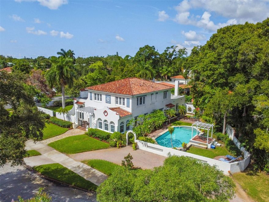 Iconic 1925 Spanish Mediterranean Revival estate with water lot/dock in the historic district of Granada Terrace in the Old Northeast! Located on a corner lot of premier Coffee Pot Boulevard’s waterfront brick-lined street with gorgeous water views from almost every room, this exquisite 4-bedroom, 3,637-square-foot estate includes 3 full baths, 2 half baths, pool, detached 2-car garage and water lot/dock (updated 2023), and is a designated historic building. Although there are no special interior historic renovation restrictions, renovations were completed to enhance the space for modern day living while seamlessly blending the home’s special historic architectural heritage. Built in 1925 during Florida’s Golden Age by prominent pioneer architect Edgar Ferdon (who built many of our city’s landmark buildings), it was considered one of the most ambitious Mediterranean Revival homes of the time and maintains the designation as one of the contributing buildings for design in Granada Terrace. Known as the Godsey House in the 1920s, the owners, CJ Godsey, a prominent plumbing contractor and businessman along with his wife, a professionally trained soprano who sang locally on the radio and at numerous society events, spared no expense on the design as they widely entertained society events and philanthropic endeavors in this stunning home. Built with superior hollow tile construction, this elegant home features exquisite historical details such graceful arches, original wood floors with Cabin Corner design, superb millwork, original gas fireplace, 11-foot ceilings, dazzling chandelier and sconces, custom-designed original stairwell spindles and exceptional original baths showcasing the owner’s professional prowess. The inviting solarium features two shared design elements with the renowned Vinoy Hotel (also built in 1925) including original hand-stenciled pecky cypress ceiling clad beams installed to the architect’s intricate design and original handcrafted faience tile on the solarium floors and gas fireplace. The light-filled, eat-in kitchen was meticulously updated to an open-concept family room/kitchen design perfect for entertaining and features custom wood cabinetry milled to match the period, pot filler, custom-designed glass tile backsplash, Corian countertops hand-picked for their luster and authentic appearance, sleek stainless steel appliances including stainless steel farmhouse sink, convenient center island with drawer microwave, designer pendant lighting, tile floor sourced to match the original as well as a handy breakfast bar overlooking the refreshing pool and Coffee Pot Bayou waterfront. Relax in the tranquil second-floor spacious primary suite overlooking the waterfront featuring 3 closets (one walk-in) and includes an ensuite bath with beautiful stain glass, original fixtures and a remarkable original cathedral tile ceiling. A second bedroom includes waterfront views and an ensuite bath with original fixtures and finishes plus another extraordinary original cathedral tile ceiling. Rounding off the second floor are two additional bedrooms and guest bath. Entertain friends and family on the tropically landscaped pool deck with pergola perfect for dining alfresco. Surrounded by a masonry wall, the grounds (14,693 square feet) include plenty of green space, basketball court, storage building with copper door, and semi-circular driveway for parking. Located near beautiful waterfront parks and exceptional downtown St Petersburg.