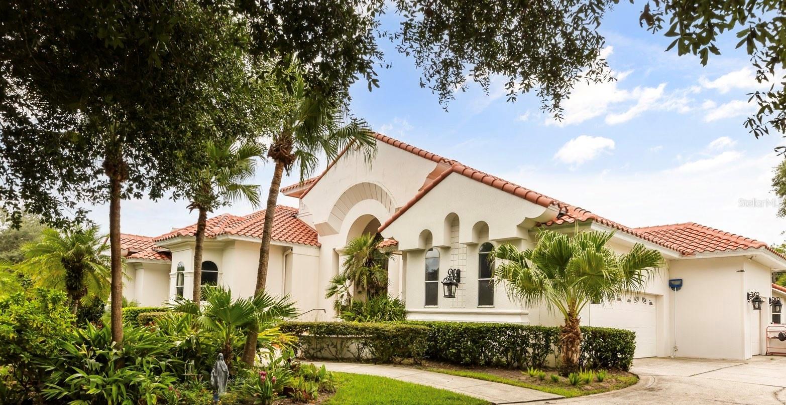 Discover an extraordinary golf-front residence overlooking the 14th green of Sweetwater Country Club, nestled within the exclusive gated community of Sweetwater Greens. This custom executive home, a collaboration between renowned architect John Henry and builder Ken Watkins, blends timeless design with exceptional craftsmanship.
Boasting nearly 3,700 square feet of open, elegant living space, this home is designed for both everyday comfort and unforgettable entertaining. Soaring 30’+ ceilings in the foyer, living room, family room, and kitchen flood the interiors with natural light while showcasing sweeping views of the private pool and lush golf course.
Step outside to a solar-heated saltwater pool and ledge rock spa, surrounded by tranquil water features including a marble entry fountain and a dramatic river fountain at the drive. Inside, the spacious owner’s suite offers a private sitting room, vaulted ceilings, a cozy gas fireplace, dual walk-in closets with custom organizers, a spa-like bath with two-person whirlpool tub, oversized shower, and exquisite marble finishes.
A thoughtfully designed 2/2 split bedroom layout provides flexibility, whether as a private guest suite, in-law quarters, or teen retreat. Throughout the home, custom details abound: Entegra barrel tile roof, transom windows, double-sided fireplaces, granite counters, marble floors, arches, columns, Kohler fixtures, Baldwin hardware, and refined millwork.
The property’s long private driveway, mature landscaping, and fenced play or pet area ensure peace and privacy. A three-car side-entry garage completes the estate-style appeal.
Living here means enjoying one of Central Florida’s premier golf communities, with Sweetwater Country Club recently renovated and conveniently located near shopping, dining, parks, schools, and hospitals.
This one-of-a-kind home combines resort-style living with unmatched privacy and architectural beauty — ready to welcome its next discerning owner.