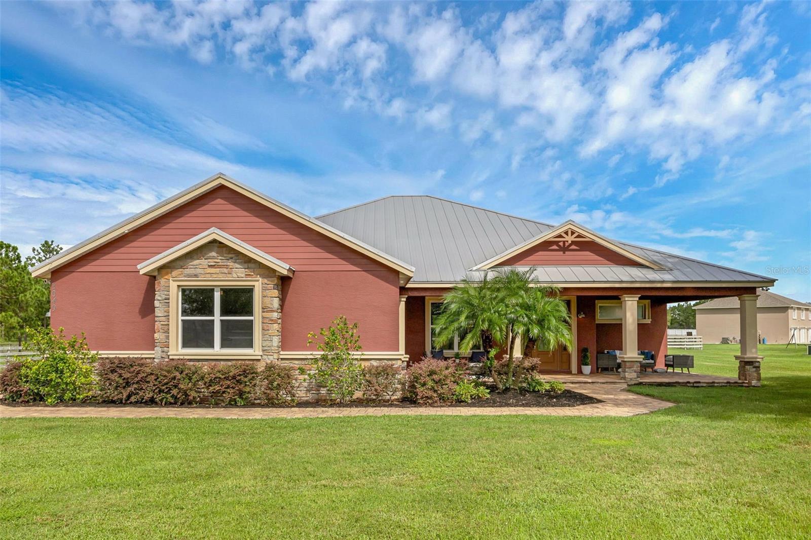 Move-in ready 2021 custom home on 1.6+ acres with hurricane-strong construction, standing seam metal roof, upgraded insulation, and energy-efficient windows. Features include fenced pasture for animals, irrigation system, deep private well, and water filtration. Enjoy a paver driveway, screened porch, and open floor plan with gas fireplace. The kitchen offers sealed marble counters and modern finishes. The spacious primary suite boasts abundant natural light, dual shower heads, a soaking tub, and a large walk-in closet. No HOA. A perfect blend of modern efficiency and country charm—ready for its next owner.