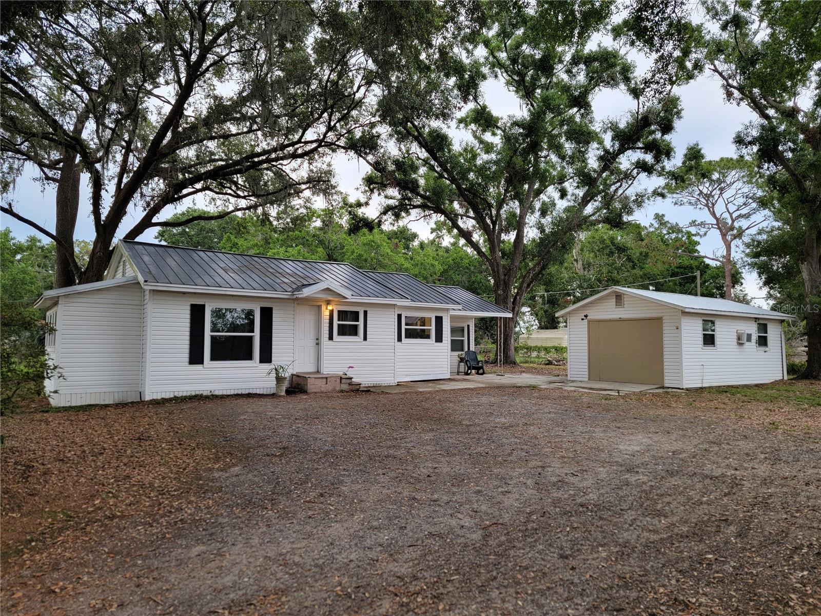Opportunity knocks - Great investment property or make it your own home sweet home! Beautiful .47 acre FENCED-IN lot located in a serene country setting yet close to everything. This charming historic Seffner home has the windows and AC updated, along with a metal roof in good condition. The property features two large additional buildings. The garage is converted into a studio featuring ceramic flooring throughout with a 1/2 bath inside. The other building is a large shed/workshop with electricity. Outside, you'll enjoy a spacious yard - perfect for gardening, gatherings, or storing a boat or RV. Located in a quiet yet convenient neighborhood, you’ll be just minutes from parks, shopping centers, dining spots, and within minutes of I-4 and I-75. NO HOA and NO CDD!! Schedule your showing today before it's gone!