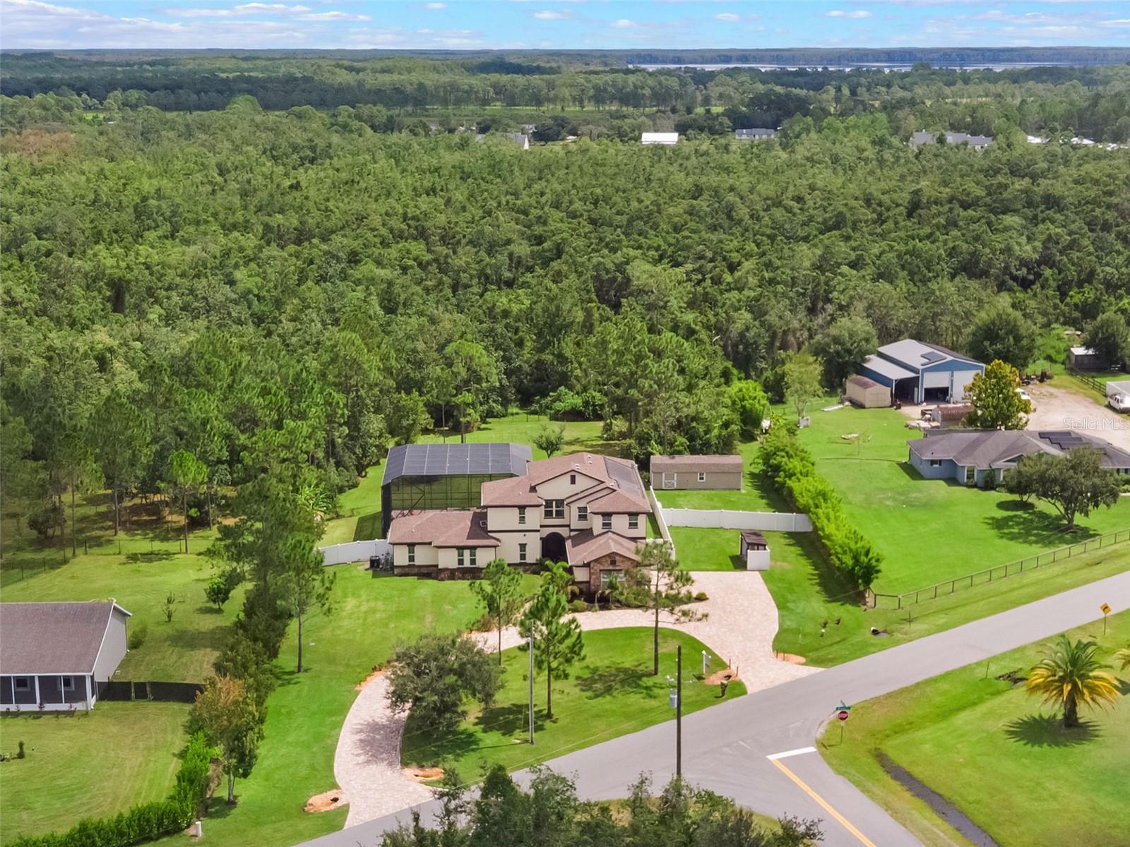**PRICE REDUCED OVER $150,000*** Welcome to an incredible home featuring a rare blend of custom design and room to roam!! This multifamily compound offers a beautiful In-Law Suite with a separate entrance. With 3 bedrooms, 3 1/2 baths in the Main home and an additional 2bedrooms & 2 baths in the In-law suite / guest house, this is truly the PERFECT place to escape the hustle and bustle of the city (but still be close enough to all modern conveniences)!You get TWO homes for the price of one ... all on OVER 3 Acres! Welcome to a whole new way of life -with a home that seamlessly blends indoor and outdoor living while offering quality, comfort, and just the right touch of casual elegance. Located in one of St. Cloud's most popular & desirable neighborhoods, this property is truly One-of-a-Kind! Ideal for multi-generational living offering an impressive in-law suite with private entrance - and a fully-equipped SECOND Kitchen, cozy living room and 2 ensuite bedroom/baths (it could even work well as a art studio, home office or gym!). The main home is expertly designed with an open-concept layout that showcases soaring 25-foot ceilings, floor-to-ceiling windows, 18-ft retractable sliding glass doors that allow for the perfect blend of indoor-outdoor living, and is anchored by a chef-inspired kitchen boasting double islands, solid wood cabinetry, granite countertops, stainless steel appliances, and dual sinks. But that's not all, an upstairs loft and TWO balconies on the second floor offer additional living and relaxation space with views of the stunning pool area and surrounding landscape.
The outdoor living is in a league of its own ... a spectacular retreat with a custom-designed oversized saltwater pool and spa (solar heated) under an impressive screen enclosure, and surrounded by stone pavers & beautiful landscaping. This property offers the best of all lifestyles with endless possibilities: zoned agricultural + allows horses, farm animals, and accessory dwellings! Situated on over 3 usable acres (over 1-acre currently cleared and fenced) **with no flood zone or HOA restrictions**, and includes a dedicated RV parking space in back with septic, power & water hookups, a separate garage/workshop with power & water connections, an oversized septic system to accommodate future additions and an oversized circular driveway that fits over a dozen vehicles! Nearly 1 acre is fenced already while the remaining 2+ acres maintains its natural character with a few cleared trails suitable for exploring or recreational use ... and with *No HOA restrictions*, you can make this anything you heart desires!
The construction of this home is top-notch with energy-saving features like foam insulation in the walls and ceilings, high-foil radiant barrier on the first floor to keep you comfortable during those hot summer months (and keep the electric bills LOW!), a whole-house water filtration and softener system, irrigation well, and an oversized anti-gravity septic system.
Bay Lake Ranch is a golf cart–friendly community known for seasonal neighborhood events and offers convenient access to area lakes, parks, conservation trails, and downtown St. Cloud. A short drive to Lake Nona Medical City, Orlando International Airport, and even the beautiful Brevard County beaches!