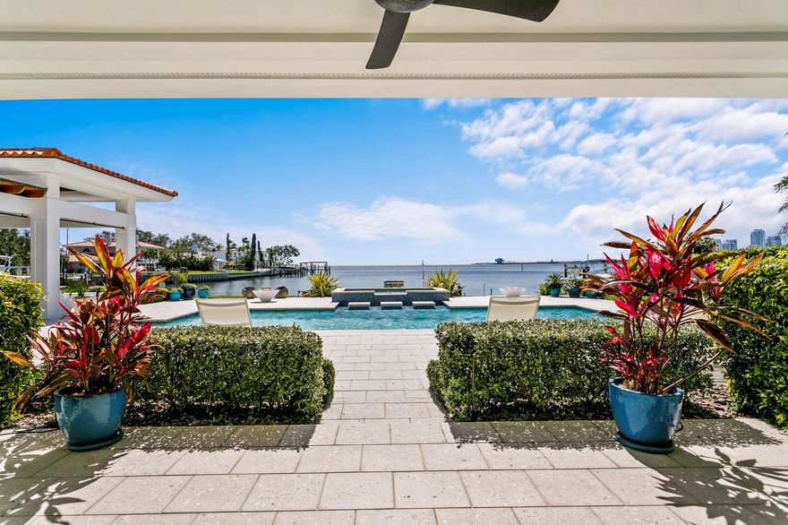 **No flooding in main living areas of home during the storms**. Magical Waterfront Mid-Century Modern Luxury. With sweeping sunrise and sunset views of Tampa Bay and downtown St. Petersburg, escape to this reimagined southern-facing Snell Isle waterfront estate.  Representing architectural significance and flair on 0.4 acres with 100 feet of bay frontage in the coveted Brightwaters neighborhood. Experience unparalleled living and entertaining, indoors and out. A marble foyer boasts floor-to-ceiling window views of a gated and walled courtyard—dappled with the shade of majestic live oaks and enhanced by a modern water feature. Imagine expansive views and light-filled living spaces via NanaWall floor-to-ceiling accordion doors that seamlessly blend the indoor and outdoor areas. From the impressive foyer to a flowing plan that draws focus to the resort pool and water views beyond, the living room features custom built-ins and window treatments, accented by a gas fireplace in the lounge for cool nights. The formal dining room flows to the chef’s dream kitchen that is sure to impress with attention to detail in a quartz island, Miele professional range, dual ovens, dual full-size refrigerators, a beverage drawer, ice maker, and wine refrigerator for effortless entertaining. Clean-up is a breeze with dual dishwashers, a farmhouse granite sink, and a spacious butler’s pantry. Just off the butler’s pantry, an interior, brick-lined mechanicals room offers the perfect opportunity for future wine storage or a secure shelter. The first floor primary suite delivers a private retreat with a luxurious bath and private waterfront lanai.  An additional first level ensuite guest room boasts a private entrance and pool access. Laundry and an office complete the first level. Upstairs, a second primary suite provides a secluded sanctuary with a private covered terrace. The second level also features two additional guest bedrooms and baths. Immerse yourself in outstanding manicured grounds and an expansive covered lanai featuring custom fiberglass built-in seating, gas fire bowls, a waterfront saltwater pool and spa with a cascading waterfall, complemented by a full-service composite dock for water sport and nature enthusiasts. Additional highlights include new generator, updated systems and mechanicals, hurricane-rated windows, copper gutters, a tile roof, a gracious paved circular driveway with garage, built-in cabinetry and separate storage room. The spectacular Brightwaters waterfront location offers the very best of privacy and convenience. Minutes to downtown St. Petersburg’s numerous galleries, museums, restaurants, private schools, and less than 30 minutes to Tampa International Airport, enjoy access to parks, recreation, and award-winning beaches.