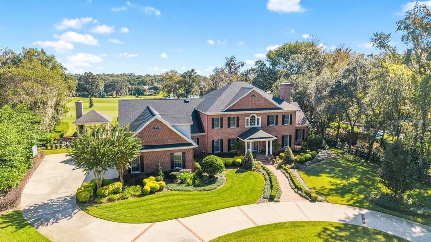 This stunning two-story red brick estate offers timeless charm, modern updates and breathtaking golf course views overlooking the 15th hole and beyond. Featuring 4 bedrooms, 3 full baths and 2 half baths, every space has been thoughtfully designed for everyday living. Step through the foyer and you’re greeted by a custom staircase leading to the second floor of the home. The main floor features a formal living room with a fireplace and mantle that have been beautifully updated, a spacious formal dining room and a family room that extends 2 stories, where walls of windows fill the space with natural light. A second wood-burning fireplace framed by custom built-ins anchors this inviting gathering space. The gourmet kitchen, fully remodeled in 2018,  truly is the heart of the home with white wood cabinetry, gorgeous granite countertops, double ovens and a thoughtful layout that opens to a breakfast area and cozy sitting room, complete with a built in cabinet and beverage bar. The refinished hardwood floors flow beautifully throughout this space, extending to the staircase that leads to a large bonus/media room. The primary suite, completely redesigned in 2023, has exquisite finishes and a spa-inspired bath. Up the main staircase, you’ll find a loft area with a built-in desk and three additional bedrooms, with two sharing a Jack-and-Jill bath and one with a private ensuite, both featuring updated showers and modern touches. Outdoors, enjoy your own private oasis. The saltwater pool, fully redone in 2024 with new marcite, stone and updated pool equipment is surrounded by beautiful bluestone pavers and is fully fenced with a gate for privacy. Entertain year-round under the 25' x 25' pavilion, complete with a wood-burning fireplace and TV hookup, making it the ultimate space for weekend gatherings or quiet evenings by the fire. In addition, the grounds are beautifully landscaped and enhanced by extensive landscape lighting. Additional highlights include an air-conditioned and tiled 3-car garage, perfect for a workshop or home gym. The laundry room update (scheduled for completion December 2025) will feature custom cabinetry matching the kitchen for a cohesive, elevated look throughout the home. This home also has a tankless hot water heater, whole house generator, brand new sub zero refrigerator and all electric drapes. Don't miss this one in the beautiful Country Club of Ocala.