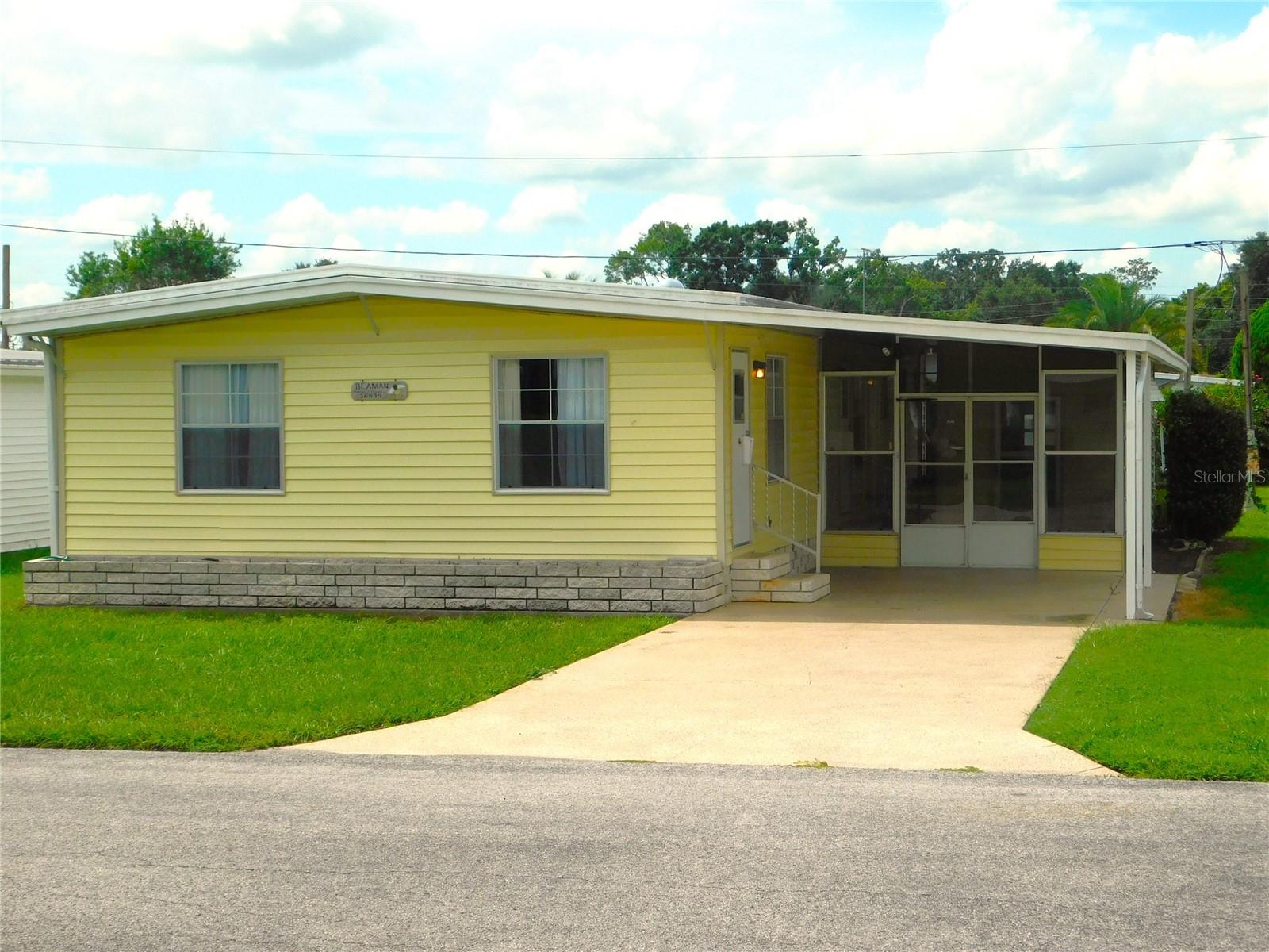 Looking for a home to get away from the northern winters? Step into this 2 bedroom, 2 bath home located in an active 55+ community. The home has vinyl siding, a metal roof-over and the A/C unit was installed in 2017. Walking into the home, the first room could be used as an office, craft room or den. The spacious living room has several windows that offer lots of natural light, and has Berber carpeting . The kitchen and dining area are open, for effortless socializing and entertaining. The kitchen,, is equipped with refrigerator, dishwasher, stove, and ample cabinetry, ensuring both functionality and style. The primary bedroom offers a peaceful retreat, complete with a sizable closet and an ensuite bathroom with a walk-in shower. Meanwhile, the second bedroom provides versatility, whether utilized as a cozy guest room, a home office, or a hobby space. The adjacent bathroom is thoughtfully designed with a tub-shower combination, catering to diverse preferences. Beyond the confines of the home, the community beckons with an array of amenities tailored to an active lifestyle. Residents can partake in social gatherings at the clubhouse, or bask in the sunshine at the poolside. Walking trails wind through the community, offering opportunities for leisurely strolls amidst scenic surroundings. As the sun sets, residents gather for lively events and activities, fostering a sense of camaraderie and belonging. Whether engaging in group outings, game nights, or educational workshops, there's always something exciting happening within this vibrant community. And remember to check out the 27 hole golf course, 2 swimming pools and 2 hot tubs along with 3 clubhouses, a library, walking paths, game rooms , enclosed shuffleboard courts, tennis courts, pickle-ball courts, basketball court, and weekly cash Bingo. With its blend of comfortable living spaces, modern amenities, and a lively social atmosphere, this 2 bedroom, 2 bath home embodies the essence of carefree and fulfilling living in an active 55+ community.