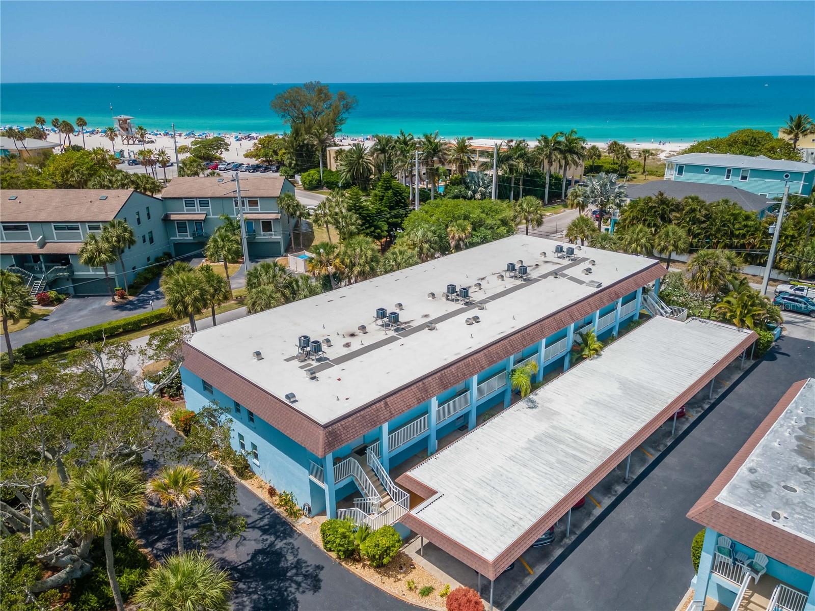 HUGE PRICE DROP - MOTIVATED SELLER - Welcome to Cayman Cay located in Holmes Beach on Beautiful Anna Maria Island! This unit stood firm during the 2024 Hurricane Season.  Unit 103 is a first-floor unit, but was never damaged as the three hurricanes passed through Anna Maria Island.  The condo is a GOOD INVESTMENT as well as an EXCELLENT VACATION HOME. 2025 has already generated $40k in rentals. Upon entering the unit you will see a COMPLETELY UPDATED condominium, redone from the studs with Hurricane windows and doors, easy care tile floors and finished with a COASTAL DECOR.  The kitchen has beautiful quartz countertops and a beachy backsplash. Two bedrooms and bathrooms give you room to invite family and friends.  The ensuite master bedroom is large and has plenty of closet space.  Enjoy a cup of coffee on the Lanai, or a glass of wine in the evening as you breathe in the salty air. Offered TURNKEY with all the kitchen necessities that you will ever need.  All you will have to do is unpack and enjoy the island.  Cayman Cay is located only steps to the sugary sand, and a block to Publix grocery and liquor store, along with other convenient shops, and wonderful restaurants.  There is a sparkling heated pool, a grill area, and a shuffleboard court for your entertainment.  MANATEE BEACH IS ACROSS THE STREET (about 400 steps away) where there is a restaurant, bar, gift shop, restrooms, showers, changing rooms, volleyball nets, playground, and it is where the Island Free Trolley stops.  To complete the Island experience there are beach essentials in the conveniently located storage unit next to the parking place. It is stocked with beach chairs, sand toys, a beach cart, and a beach umbrella for warm sunny days. All the items a real beach lover will appreciate. Just pack your suitcase and come on down to your Beach Paradise!