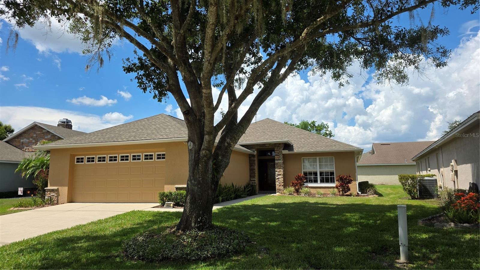 From the moment you arrive, you’ll be captivated by manicured Florida foliage, vibrant flowers, and stately stone elevation that radiates charm and prestige. Nestled inside a gated community, this one-story gem with tranquil pond view blends comfort and style into one highly desired lifestyle. And the best part? Lawn care is included—so you can travel, take advantage of fun-filled neighborhood amenities, or simply relax at home. A stunning 8-foot front door with matching sidelites leads you into high and coffered ceilings, custom built-ins, and handsome barn doors throughout this wonderful home. Rich wood flooring flows through the living and bedroom spaces, while gorgeous wood-look planks carry the warmth into the kitchen, dinette, laundry, and baths (no carpet anywhere!). Recessed and classy ceiling-fan lighting add charm and ambiance to every room. For the cook who loves to entertain, the showstopper kitchen blends function and flair with ease. Designer 42-inch upper cabinets with crowns plus solid-surface countertops surround the kitchen. The chef-inspired design includes a double-oven range (with convection!), corner walk-in pantry, stainless-steel appliances, and a deep sink that overlooks the breakfast bar into the family room—perfect for catching TV shows while prepping culinary delights. Open the triple sliding glass doors and step into your serene sunroom with floor-to-ceiling windows. Take in the peaceful pond view and the soothing sound of the water fountain—a sanctuary for morning coffee and evening libations. From the sunroom, enter the primary suite with spa-like indulgence. Its magical ensuite bathroom is a true retreat to unwind in a freestanding soaking tub, savor a separate tiled shower with rain head, appreciate the granite double-sink vanity with undermount sinks, and relish your custom-designed walk-in closet with ample organization. Two more big bedrooms feature retractable ceiling fans with lights and share a comfy bathroom complete with solid vanity and spacious shower with wall-width niche and rain head. The fourth bedroom is multifunctional with built-in custom cabinetry from floor to ceiling and all along the ten-foot wall! This closet system is the utmost in space-saving efficiency with multiple hanging areas, adjustable shelves, and cubbies. This extraordinary home is as practical as it is beautiful. Multiple smart locks and thermostat for convenience, high-quality faucets and door handles, luxury window and door shades, spacious laundry room with storage, solid shelving in all closets and pantry. Whole-house gutters: Check! Private mailbox: Check! Immaculately clean and ready to move in: Check! And it gets even better: 2021 roof and 2022 HVAC. The oversized two-car garage sports a door keypad, epoxy-coated floor, natural light door windows, and built-in cabinets. Ride your golf cart or stroll to the vacation-style amenities that include a clubhouse with fitness equipment and full-kitchen event space, sparkling pool and spa, tennis/pickleball court, dog run, and fishing pier. Within a half-mile are restaurants, grocery and home stores, shopping centers. Take advantage of Lakeland's multiple golf courses, hiking/nature trails, lakes, and entertainment venues. Nestled between the Gulf and Atlantic beaches, plus near the world's most famous theme parks and international airports, you can live as active or relaxed as you desire. Where Florida charm meets modern comfort, this isn’t just a home—it’s a lifestyle.