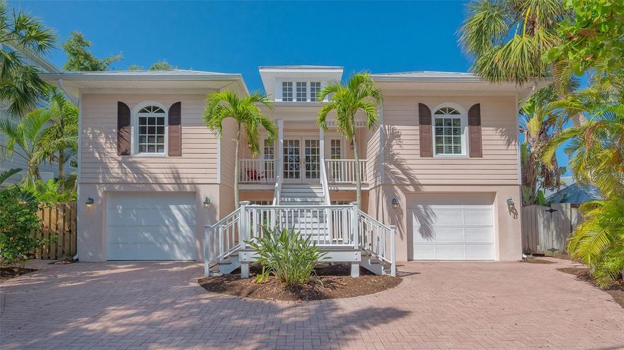 Nestled in the quaint neighborhood along the Grand Canal on Siesta Key, this Key West style home offers the perfect blend of old-world charm and modern living. This exceptionally well-appointed custom-built home is being offered turnkey. The home's grand entrance welcomes you through a covered porch that leads to an oversized foyer. You are greeted with a spectacular open floor plan, where an abundance of natural light, beautiful canal views, soaring ceilings and gleaming hardwood floors create a bright and airy atmosphere throughout. You will then be charmed by the library with a sliding ladder, wood burning fireplace, walnut wood flooring, and cedar beams in the living room, all combined with modern style furniture. The open living area includes a kitchen, with cherry wood cabinets, and an Iron Elmira stove surrounded by Chicago brick, gorgeous dining room and a breakfast nook.  Floor to ceiling windows and sliding doors seamlessly connect the grand living area to the outside covered deck, perfect for entertaining. The beautiful primary suite with canal views is on the main level and two generously sized bedrooms with their en-suite bathrooms are located on the upper level. A “basement room” between the two garages offers a huge amount of storage with built-in closets and cabinets. The house was not affected by any wind or flood damage thanks to its solid concrete block construction and 11ft elevation of living space. Some water intrusion on garage level, but did not cause any damage to building, or cabinets in storage area between the garages. 
The fenced-in backyard features a 35ft screened heated pool with a waterfall and Chicago brick deck. The 60ft IPE hardwood boat dock with a tropical over-the-water gazebo is equipped with a 10,000lb boat lift and offers plenty of space for all your outdoor toys. Boating just one mile through the deep-water canal brings you to the Intercoastal Waterway which leads right out into the open Gulf. 
In a market where quality counts more than ever, this home offers a rare blend of location, craftsmanship, and timeless appeal. Welcome home to Siesta Key - island living, breath-taking sunsets, boating and award-winning beaches, all at your doorstep.