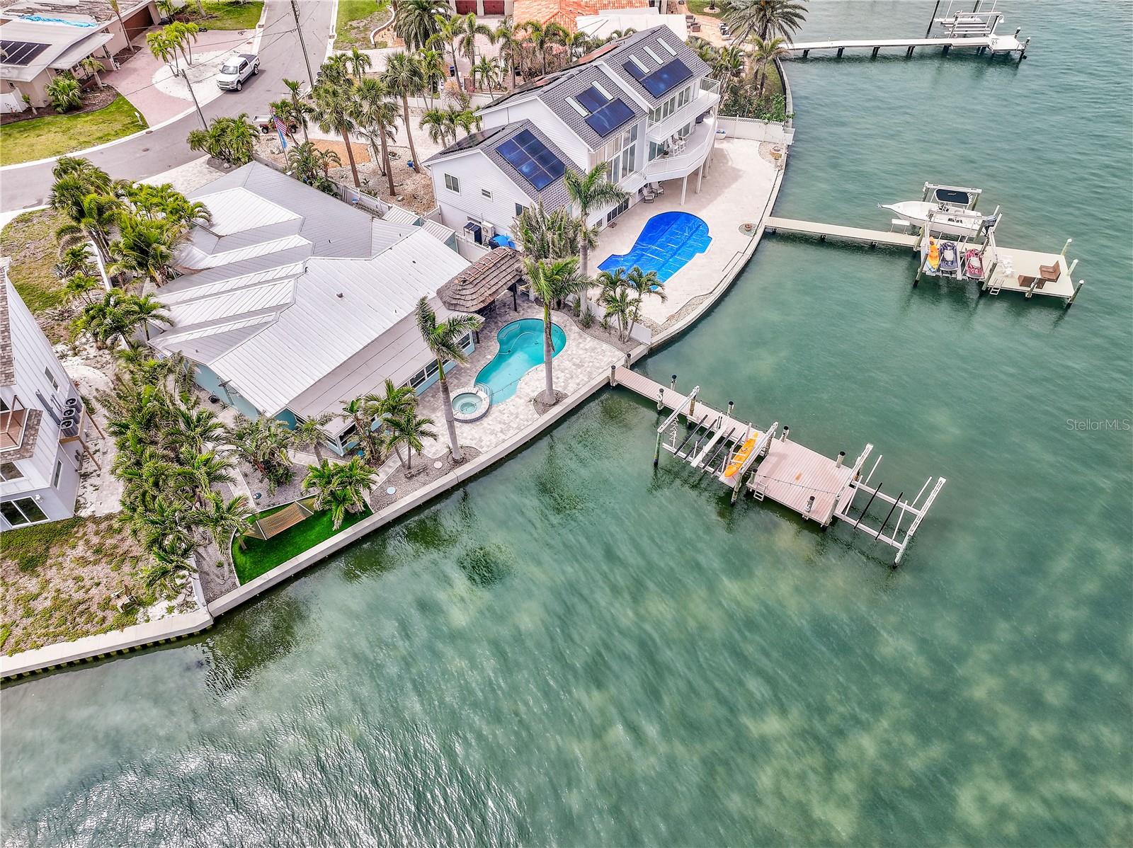 Stunning wide open waterfront home in highly desirable St. Pete Beach! This completely renovated 4-bedroom, 2-bath residence offers nearly 3,000 sq ft of coastal luxury living with breathtaking water views and top-tier amenities throughout. Hammerhead 49" High Aluminum Panel Flood Plank system added for flood protection at all entries to the house. Outside, enjoy the ultimate Florida lifestyle with a heated pool, spillover spa, outdoor kitchen, and expansive dock equipped with water/electric, 10,000 lb boat lift, two powered wave runner lifts, kayak station, and a spacious sun deck. Professionally landscaped grounds feature paver walkways, lush tropical palms, waterside hammock retreat, and ambient & low-voltage lighting ideal for evening entertaining. The oversized 2-car garage is a standout with high-end flooring, overhead storage, mini workshop, outdoor shower, and side access to two large storage shed. Inside, the split floor plan is anchored by a chef's dream kitchen with stainless steel appliances, wine fridge, ample pantry space, and oversized counters for entertaining. The luxurious primary suite offers dual vanities, deep soaking tub, frameless glass shower, private water closet, and a custom wardrobe room. Additional features include walk-in closets, large interior laundry, and a massive in-home storage room. This is an exceptional opportunity to own a move-in ready waterfront home with all the extras — perfect for boaters, entertainers, or anyone looking to enjoy the very best of beachside living. Current tenant in place paying $9,500 per month.