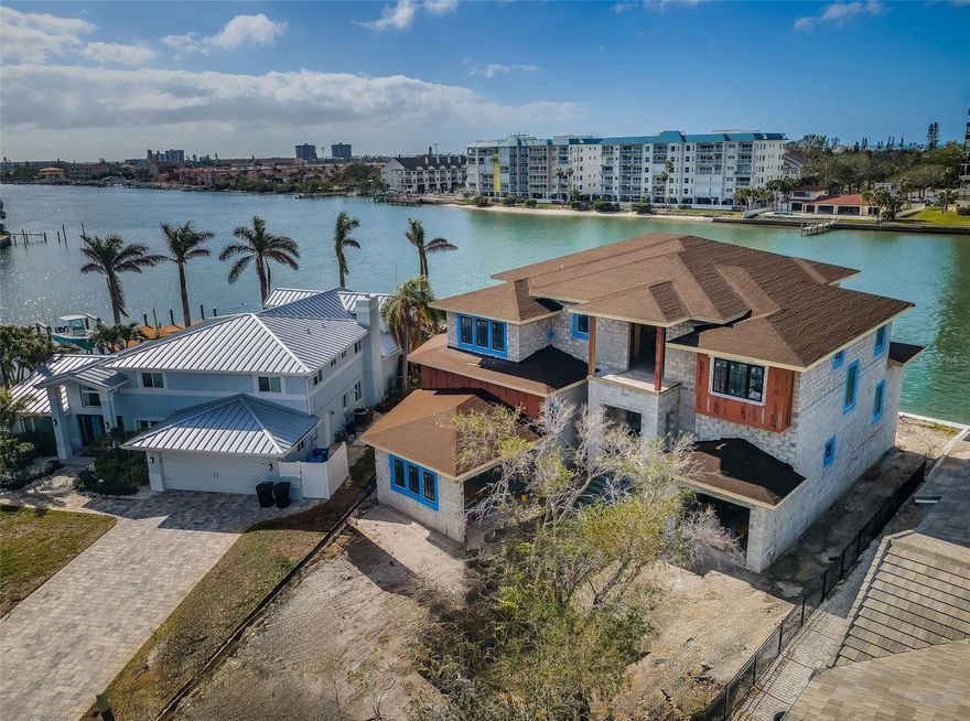 One or more photo(s) has been virtually staged. Under Construction. Note: Some of the included images are conceptual renderings; the colors and color schemes may have been changed. COMING IN JUNE 2025. UNDER CONSTRUCTION BY BOSS & MENNIE LUXURY HOME BUILDERS, THIS BRILLIANTLY-CONCEIVED CONCRETE BLOCK COASTAL-CONTEMPORARY WATERFRONT ESTATE IS LOCATED DIRECTLY ON THE INTRACOASTAL WATERWAY! With impeccable luxury finishes, a terrific and well-designed floor plan, 5 elegant bedroom suites (with walk-in closets), and 7182sqft under roof, this remarkable home breathes sophistication, grace and style. With the influence and design of renowned Accentrics Interiors, you’ll love the exceptional ceiling details, level 5 drywall finishes, high-end windows and doors, and radiant modern lighting of a residence that delivers a rich, lavish appeal. The large open great room with fireplace, is complemented a gorgeous chef’s kitchen with quartz surfaces, shaker-style cabinetry, a high-quality appliance package, gas cooking, terrific island breakfast bar, and a superb walk-in catering kitchen. Dining area features a beautiful wine display area and built-in wet bar/serving buffet with wine/beverage chiller. Owner’s suite with sitting area overlooking the water, has two walk-in closets and opens to the waterfront balcony. The lavish owner’s bath offers two luxurious vanities, a superb glass-enclosed shower area and a pampering stand-alone soaking tub. 2nd and 5th bedrooms overlook the water and open to waterfront balconies. Huge upper-level bonus/game room enjoys vaulted ceilings and opens to front and rear balconies. A wide covered lanai/balcony deck provides a built-in outdoor kitchen and several sitting/dining/lounging areas. Step down to the pool/spa deck and enjoy its additional lounging and entertainment spaces. There are laundry rooms located on both living levels, providing a rare convenience. Natural gas appliances, tankless hot water heating, smart home technology wiring package, interior wall insulated sound-proofing, 3-stop elevator, epoxy-coated garage floors, new seawall and many, many valuable extras. Located on a cul de sac in one of Tampa Bay’s premier waterfront communities, this dazzling showcase home and its stunning curb-side appeal will satisfy the needs of the most discriminating waterfront buyer. An exceptional new construction waterfront value! Dimensions are estimates, buyer to verify.