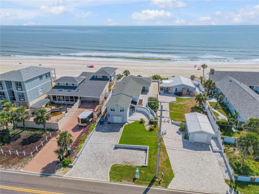 Absolutely charming direct oceanfront home perched on a high dune with breathtaking panoramas of the Atlantic. This property must be seen in person to be appreciated; it is arguably the very best value for oceanfront living in Volusia County and is not expected to last at this price. The owners took a sturdy yet adorable 1947 built classic beach cottage and spent a fortune renovating and updating every inch without compromising the charm of the original era. This home could not be duplicated anywhere near the asking price with new impact windows, electrical, plumbing, a Hardie Plank exterior, and a complete interior renovation with top-of-the-line appointments. Step inside to be greeted by forever horizon views and gain perspective on the rare towering elevation of this particular lot (one of the highest). 
The wide open great-room is the ultimate waterfront gathering area, featuring two gracious picture windows that bring the outdoors in. The coastal contemporary kitchen with custom cabinetry and lovely quartz tops subtly merges with the light filled dining and lounging areas of the great room where a door centered on the east wall opens onto the waterfront patio and private walkway to the beach. The room count includes 4 bedrooms, 2 beautiful bathrooms, and two separate dens, making it ideal for hosting a large family or a crowd of weekend guests. An indoor laundry area off the kitchen makes cleaning up convenient. A private outdoor beach shower is priceless after a dip in the ocean. Vertical seawall is in place for peace of mind. The photos look great, but you have to see this home in person to feel the integrity of the structure and take in the views. While this property was assigned a Port Orange address by the postal service, it is not within the city limits of Port Orange, but rather a more desirable unincorporated section of Volusia County known as Wilbur-by-the-Sea. Residents and seasonal visitors in Historic Wilbur by the Sea form a unique community that embraces beach life and the eclectic architecture of the bungalows and cottages dotting the rolling dunes from the ocean to the Intracoastal. There, the beloved Wilbur Boat House has been restored and now serves as a beautiful waterfront reception hall. The town of Ponce Inlet lies about 100 feet south of the home, which offers wonderful parks, waterfront restaurants, and marinas to explore. The hard packed sand here, once famous for auto racing is ideal for riding a beach cruiser for miles. While driving on the beach is still permitted in some local areas it is not permitted on this section ensuring the only traffic will be shorebirds, turtles and beachgoers.