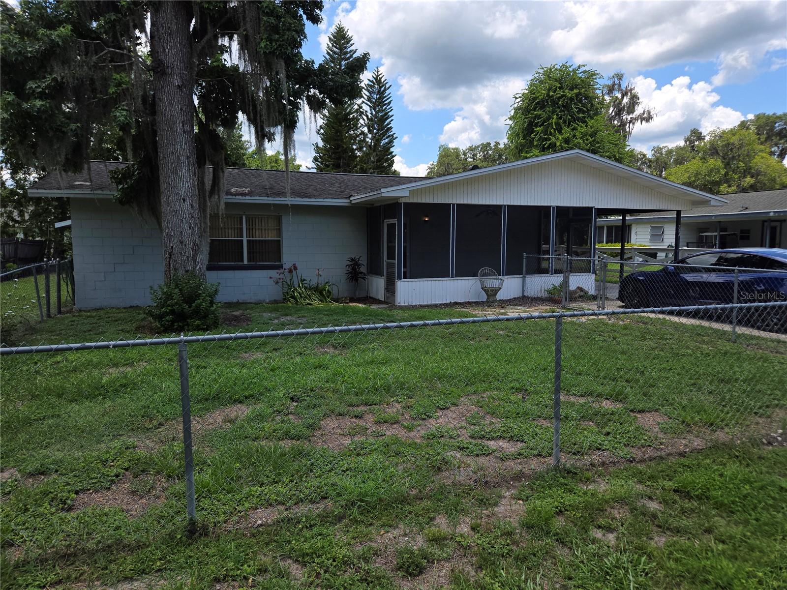 For the buyer who wishes to “get away from it all” an exciting opportunity exists between Tampa and Ocala in Sumpter County on Lake Panasoffkee, just off I-75.
This 2 bedroom, 2.5 bathroom concrete block home sits approximately100 yards by canal to the open, fresh waters of this large lake renowned for its fishing. The covered boat dock on the canal behind the home is ideal for a pontoon or fishing boat.
The home sits on a large lot with plenty of room at the side to store a boat and trailer, or a motorhome. The detached garage in the rear is ideal for a workshop or additional storage. The attached utility room sits just behind the large covered and concrete floored carport and has indoor hookups for a washer/drier, a propane water heater and a half bath.
The front yard is fenced-in and the large screened-in porch offers shade year-round. The kitchen and second bathroom will require some attention but both present projects that any handyman might like to handle.
Nearby attractions include one hour airboat rides at “Tom and Jerry’s Airboat Tours”, or within a short boat ride from home, dock your boat at the “Big Bass Lakefront Resort” and enjoy great food and live music on weekends.
Whether already retired or just looking for weekends of tranquility, this home provides a sanctuary from the fast pace of city life. If this sounds like your kind of getaway, give us a call to arrange a personal showing.