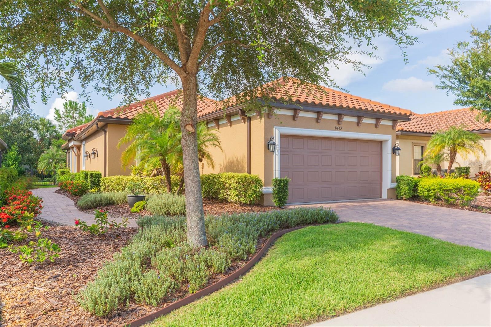 Prepare to enjoy the Florida resort lifestyle in the luxury gated neighborhood of Esplanade of Tampa. Lush landscaping greets you upon arrival to this beautiful Mediterranean style home. Enter into the foyer and notice the open floor plan and the gleaming tile floors throughout the home. The living room is light and bright and features triple sliding doors that lead to the outdoor lanai. Enjoy the ambiance of your custom built electric fireplace (year round enjoyment with heat or no heat!) Sit on the patio and enjoy the private back yard with lush landscaping that surrounds this home. The yard is fully FENCED. Chefs will love the gourmet kitchen, complete with 42” cabinets with crown molding, granite counters, decorative tile backsplash, GAS range, built in microwave and stainless steel appliances. There are plenty of cabinets and drawers PLUS lots of counter space. There is also a closet pantry for added storage. Pendant lights hang over the breakfast bar, the perfect space for your bar stools. The dining room is next to the kitchen which makes entertaining easy! The master retreat offers a large bedroom, with space for a sitting area, luxurious master bath, complete with his and her sinks and a large walk in shower, and a WALK IN closet. The second bedroom offers direct access to the hall bath, making it a perfect guest suite. The den has double French doors which make it versatile….use as an office, craft room, or additional guest area. The choice is yours! The large inside laundry room offers built in cabinets for storage. Lawn care and ground maintenance is INCLUDED in your HOA fees. NO CDD fees. Other upgrades in this home include: tankless gas water heater, all tile flooring, hurricane shutters and a long lasting TILE ROOF. The community features a clubhouse with community pool and spa, fitness center, gathering room for parties and activities, outdoor fire pit, clay TENNIS courts, PICKLEBALL courts, bocceball, and 2 dog parks. This is an active community with events for everyone including card nights, bunco, mahjong, social events, pickle ball clubs and more! Located near the Outlet Mall, Wiregrass Mall, stores, shopping and restaurants. Come and live the Esplanade life!
