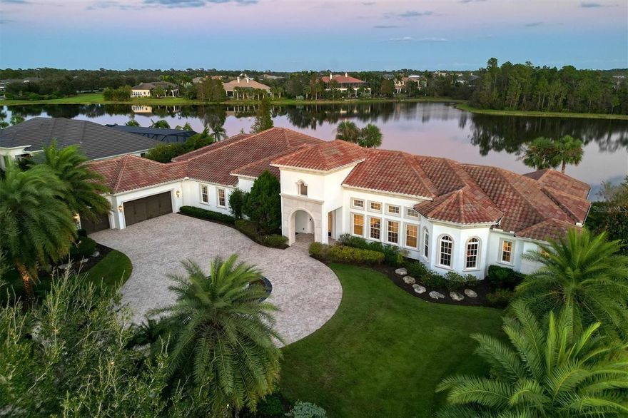 Experience indoor-outdoor luxury living at its best. Perfectly positioned amidst the beautiful landscaping to provide infinite southeast-facing lake views, this immaculate Arthur Rutenberg home combines exquisite design with quality and comfort to meet all that is needed to live the Florida lifestyle. Upon entering, the iron glass double doors and marvelous features enhance the opulence of the open floor plan with coffered ceilings, polished travertine floors throughout the main living areas, 10-foot pocketing sliders for plentiful light and picturesque views of the pool and lake beyond. The great room boasts a soaring ceiling with abundant space for hosting family and friends. Sharing this space is the large gourmet kitchen showcasing breathtaking cabinetry with under and over-cabinet lighting, a large floating island, quartz countertops, a discrete walk-in pantry, a gas Wolf cooktop, a beverage cooler and stainless steel appliances. Adjacent to the kitchen is a formal dining room that is a wonderful area for upscale entertaining with a sizable bar. There is a sophisticated office perfect for remote working. There is also an enormous gym overlooking the long water view, perfect for those with an active lifestyle. Three incredibly sized additional bedrooms provide quiet domains for the family while ensuring privacy from the owner's suite that boasts a peaceful sitting area, substantial walk-in closets and a spa-like bath, including dual vanities, a soaking tub and a walk-in shower. The enormous lanai boasts perfection complete with abundant space to relish the perfect outdoor setting with travertine pavers, a fully equipped outdoor kitchen, a saltwater pool and a spa with a sun shelf and fountains. Create the perfect outdoor oasis while you enjoy the panoramic views overlooking the peaceful lake. This home also features smart technology that controls lighting, security cameras, surround sound, temperature and much more. This luxurious home sits on 0.7003 acres of land surrounded by an iron fence and spares no features. The Concession is one of the most prestigious golf communities in the area and provides the perfect setting for those who admire a serene and tranquil environment.