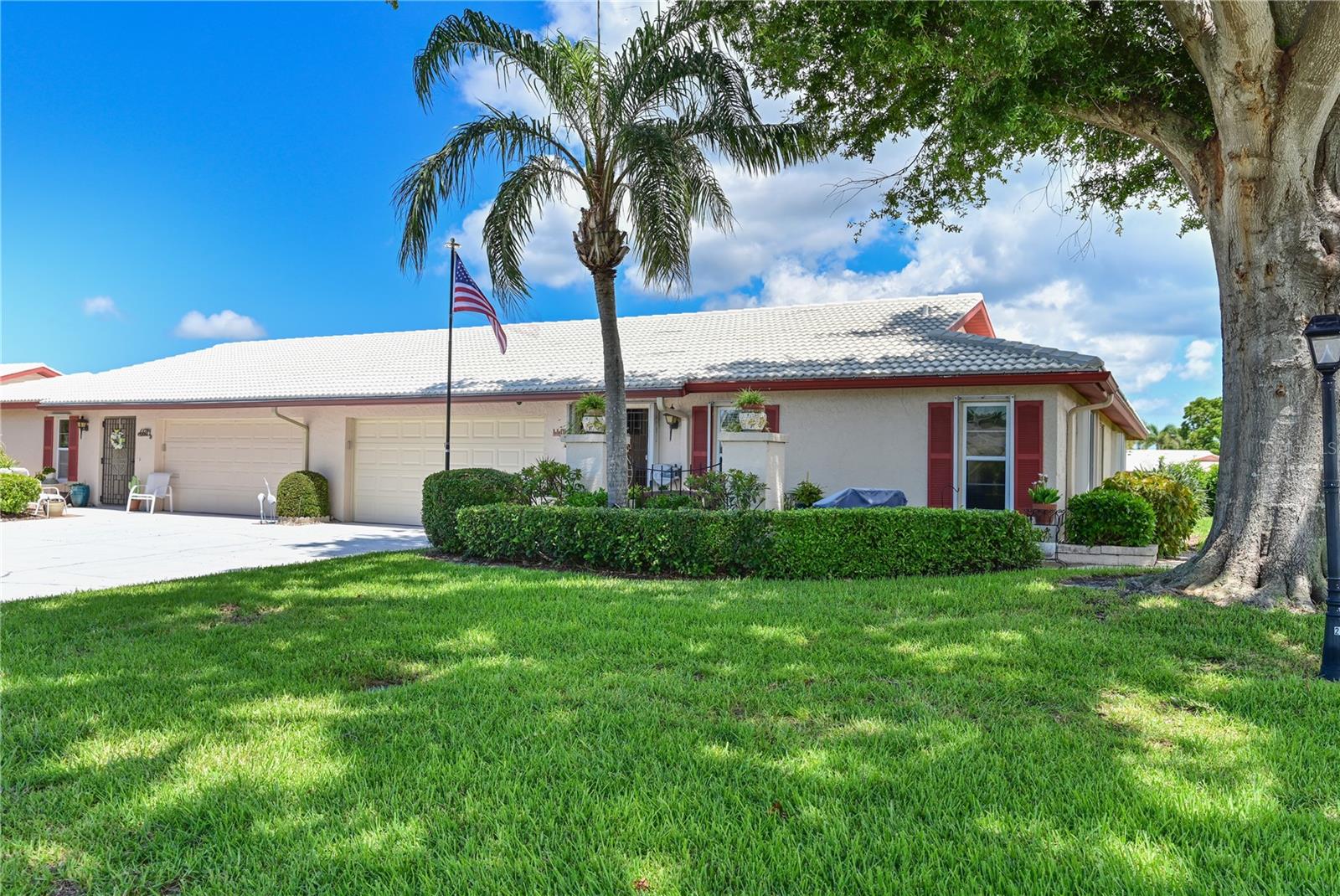 Welcome to Village Green – West Bradenton’s Premier 55+ Community. Surrounded by lush, mature landscaping, this home offers a serene, park-like setting that provides a peaceful escape. Upon approach, you'll be greeted with a cheerful pavered front courtyard, perfect for your morning coffee, an afternoon cocktail or just greeting your neighbors. Once you step inside to the bright open floor plan, you'll be wowed by this impeccably updated 2 bedroom, 2 bath, 2 car garage 2154 square foot villa offering the perfect blend of comfort, convenience and style. There are so many amazing updates that you should really make this your first choice! The kitchen has been stylishly updated with new cabinetry, including pull out soft close drawers, luxury LG stainless steel appliances, leathered granite countertops, nicely appointed fixtures and gorgeous tile backsplash. Both bathrooms have also been updated with sleek glass doors, stylish tile work, new lighting and mirrors. Even the laundry room has been updated with all new cabinetry and an additional refrigerator. Trust me...doing laundry in here won't feel like a chore. The generous floor plan offers spacious rooms filled with natural light, complemented by views of a vibrant butterfly garden and a peek-a-boo glimpse of the lake. Whether hosting friends or enjoying a quiet evening at home, this villa delivers the perfect blend of elegance, convenience, and Florida charm. Numerous upgrades include new A/C (2023), no popcorn ceilings, remote controlled blinds, updated windows, new engineered hardwood flooring, custom closets, epoxy garage floor, raised panel interior doors, water softener, hurricane shutters, wine fridge and the list goes on. Tucked away on a quiet residential street yet minutes from shopping, dining, churches, medical facilities, golf, parks, and the beautiful Gulf beaches, this location truly can’t be beat. Whether you’re seeking a year-round residence or a winter retreat, this villa offers the comfort, convenience, and style you deserve to fully embrace the Florida lifestyle. Truly a must see...you won't be disappointed!