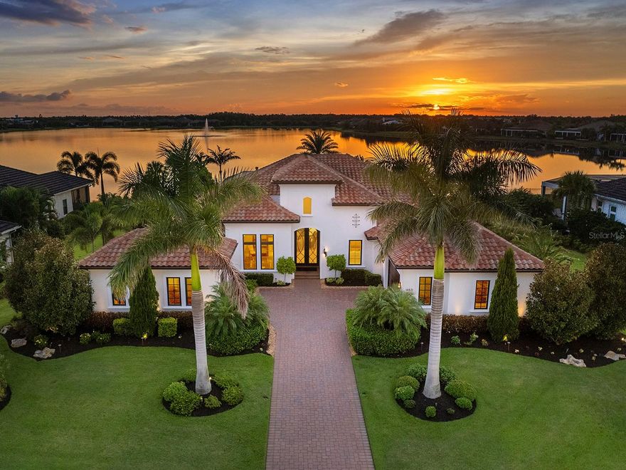 Enjoy the best of what The Lake Club has to offer with this resplendent lakeside residence. From this 2019 Arthur Rutenberg custom home the perfect Florida lifestyle comes to life with western sunset views over the expansive lake from the lanai and peaceful conservation just outside the front door. Gracing over 0.5 acres, this perfectly poised property offers privacy, lush Florida landscaping and a luxurious residence with hand selected details in every room. With over 4,100 SF of living space, this open and modern floor plan offers 4 en-suite bedrooms and 4.5 bathrooms, including a private study, flexible bonus room, and a desirable separate casita guesthouse with kitchenette. The paver driveway invites you home between towering palms and 3-car split bay garages each with their own air conditioning. Enter from the 2024 iron double door to impressive lake views from the moment you step inside where you will be enchanted by luxe upgrades including polished marble flooring, cove crown molding, designer light fixtures and custom window treatments. The great room sparkles with a custom feature wall of stacked stone, gas fireplace and custom coffered ceiling with lighting. Through impact pocketing sliding glass doors, the outdoors are seamlessly integrated into the floor plan featuring wood ceilings, travertine pavers, classic colonnade screen enclosure, 2023 Nebula star lights integrated into the pool cage, 2022 hurricane shades and outstanding lake views. The pool and spa are the perfect place to relax with sunken 360-edge spa with fountain and dual fire bowls, or spend evenings gathered around the gas firepit or dine alfresco from the outdoor kitchen. Inside the Chef’s kitchen will delight with completely custom wood cabinetry, large island with quartz counters, designer pendant lights, full height quartz backsplash, reverse osmosis, and a cleverly hidden oversized walk-in pantry with paneled door, abundant custom shelving and an additional full-size refrigerator. Cooking is a breeze with a stainless-steel appliance suite including Wolf gas range with Venta hood, Bosch dishwasher, Sub-Zero refrigerator, Wolf wall oven, Wolf microwave and Sub-Zero wine refrigerator. The dining room showcases disappearing corner impact sliders, designer light fixture, and custom dry bar with Sub-Zero wine refrigerator and stacked stone feature wall that mirrors the great room. The resplendent upgrades continue into the primary suite with engineered hardwood flooring, designer wallpaper and light fixtures, stunning lake views and dual walk-in closets. The spa-like bathroom will make you feel like you’re at the Ritz every day with a large vanity featuring dual sinks, thick stone counters, and designer lighting; modern freestanding soaking tub; glass enclosed walk-in rain shower; and private outdoor courtyard oasis. Two split guest suites offer privacy, walk-in closets and fully upgraded en-suite bathrooms; plus, there is a separate casita guesthouse with a private entrance, morning bar kitchenette, walk-in closet and en-suite bath. Additional spaces in this exceptional home include an impressive study with 2023 custom built-ins, large bonus room, powder bath, laundry with plentiful cabinetry and separate walk-in storage. Peace of mind is secured with impact windows/doors, whole-home generator, and whole-home water filtration system. The Lake Club is an exclusive premier, gated community with a Grande Clubhouse, restaurant, pool, tennis, pickleball and more.