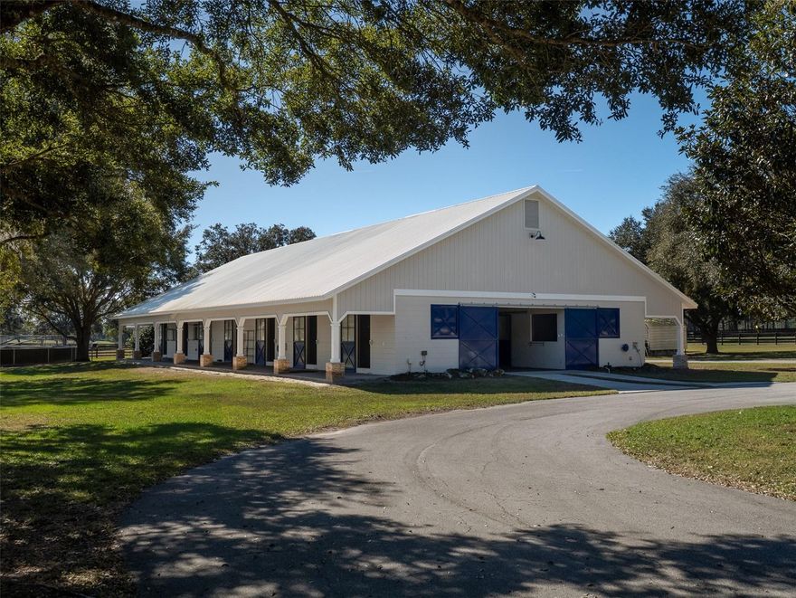 Offering 56+ acres in a sought-after equestrian location, this property combines superior horse facilities, a completely remodeled residence, and amenities designed for both performance and everyday enjoyment. Conveniently located just 16 minutes from the World Equestrian Center and only 6 minutes from HITS, the farm provides easy access to major venues while maintaining a peaceful, private setting. The 13-stall block barn with all oversized stalls is thoughtfully designed, featuring elegant chandeliers, rubber mats throughout the entire barn, excellent ventilation, and fans for year-round comfort. Additional barn amenities include an office with kitchenette, bathroom, feed room, tack room, and wash racks with hot water. The equestrian facilities are extensive and include an oversized 40,000-square-foot Wordley Martin arena encompassing a full-size dressage arena with mirrors and a full-size Grand Prix jumping arena, a 2023 European horse walker, and a large cross-country jumping field, perfect for an eventer or anyone who wants space to hack their horses out. All paddocks feature mature trees for shade and run-in shelters, ensuring comfort for horses throughout the property. The home on the property has been completely remodeled in 2024 and is bright and welcoming, highlighted by an open floor plan filled with natural light from large windows and a skylight. High ceilings enhance the sense of space, while the layout includes three bedrooms, two full bathrooms, a dedicated office, and a two-car garage. The home features tile flooring throughout with carpeted bedrooms for comfort, closets with custom built-in storage, and tasteful finishes. With a Florida room, wine fridge, and spacious kitchen featuring a large bar and prep counter, the home is perfect for everyday life as well as entertaining friends and family. The property also offers two separate areas that provide ideal sites to build a larger residence if desired. This exceptional equestrian property offers top-tier facilities, comfort, and a prime location. An adjoining 5-acre parcel is available, including additional housing, a full-size dressage arena, and a custom 6-stall barn.