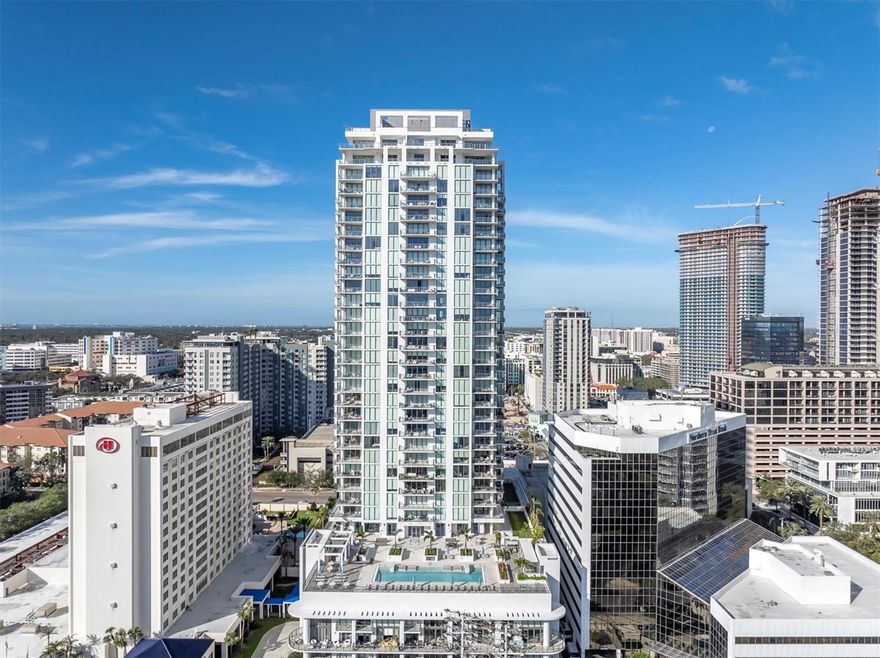 Experience elevated living at Saltaire, one of downtown St. Petersburg’s most coveted luxury high-rises, where sleek modern design is seamlessly blended with sweeping panoramic water views. This sought-after 03 Azure North floorplan showcases breathtaking vistas of Tampa Bay, the St. Pete Pier, Al Lang Stadium, Albert Whitted Airport, and the vibrant marina district, all beautifully framed by floor-to-ceiling windows with custom shades that bathe the home in natural light. Step inside to an expansive open concept layout, thoughtfully designed for both relaxed living and elegant entertaining. The Metro Collection chef’s kitchen boasts premium appliances, quartz countertops, and an oversized center island. Thoughtfully selected by an interior designer, the river rock backsplash adds organic texture and spa like warmth, serving as a beautiful focal point that balances the sleek modern finishes with natural, earthy elements. This detail carries through to the custom dry bar with built-in wine fridge, perfect for hosting guests or enjoying a quiet evening in. A seamless flow connects the kitchen to the dining and living spaces, creating an atmosphere of refined comfort.  This luxurious residence features three spacious en-suite bedrooms, a versatile den, and an additional full guest bathroom. The primary suite is a true sanctuary, offering stunning water views, dual custom walk-in closets, and a spa-inspired bathroom complete with a soaking tub, dual vanities, and a large walk-in shower. Each guest suite provides generous storage and private, well-appointed baths with high end finishes and meticulous craftsmanship. A highlight of the home is the expansive private terrace, overlooking Tampa Bay and Saltaire’s resort-style pool deck, an ideal setting to enjoy morning sunrises, fireworks displays, Rowdies games, and downtown events, all from the comfort of your own home. Additional features include two highly desirable side-by-side parking spaces in the secure garage and full access to world-class amenities located on the 7th floor. Enjoy incredible waterfront views by the resort style pool, sun deck, state-of-the-art fitness center, several beautifully designed social rooms, a pet-friendly dog park with a convenient washing station, full-time concierge services, and 24-hour secured building access for peace of mind. Perfectly situated in the heart of downtown St. Petersburg, Saltaire offers convenient access to the St. Pete Pier, more than seven miles of scenic waterfront, the Saturday Morning Market, and the exceptional dining, shopping, arts, and culture along Beach Drive and Central Avenue. Don’t miss this rare opportunity to own a luxury waterfront residence in one of Florida’s most vibrant urban communities, where style, comfort, and location come together seamlessly. Schedule your showing today!