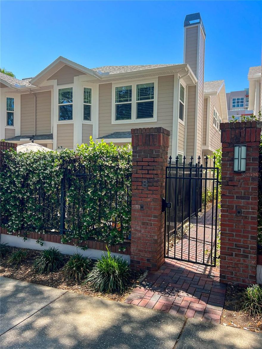 Imagine stepping out your door and being minutes away from the Sundial, Beach Dr. NE, and the St. Pete Pier! This Huntington Townhome offers sophisticated urban living with its impeccably designed 3-bedroom, 2.5 bath layout, complete with a spacious 2-car garage and located within an exclusive gated community. This coveted end unit provides a grand sense of arrival with an abundance of natural lighting through its elegant French glass doors showcased by glass accents and above transom windows, all complemented by refined designer lighting. Hurricane-impact windows provide both tranquility and peace of mind, creating a serene interior retreat from the vibrant city just beyond. Throughout the home, continuous luxury vinyl plank flooring establishes a seamless and elevated aesthetic, further enhanced by plantation shutters and thoughtfully curated finishes. The main living area exudes warmth and sophistication, centered around a beautiful stone fireplace and opening through double French doors to a generously sized private patio—an ideal setting for entertaining or quiet relaxation. The dining space is equally striking, featuring a tray ceiling and a sun-filled bay window that adds architectural distinction. The gourmet kitchen is a true showpiece, appointed with quartz countertops, custom cabinetry with crown molding, soft-close features, stainless steel appliances, a double stainless sink, and under-cabinet lighting that casts a subtle, ambient glow. The primary suite offers a luxurious retreat, highlighted by its expansive layout, multiple oversized windows including a stunning bay window, and elegant plantation shutters. A well-proportioned walk-in closet, approximately 8.2’ x 7.9’, provides ample storage. The spa-inspired primary bath is thoughtfully designed with dual vanities set on opposite sides, a private water closet, and an oversized glass-enclosed shower with a built-in bench and designer finishes. Two additional bedrooms are beautifully appointed with generous natural light, designer shades, ceiling fans, and walk-in closets, offering both comfort and versatility. The secondary bath mirrors the home’s elevated design with quartz countertops, a tub/shower combination featuring full wall tile detailing. Additional highlights include a finished two-car garage with a high performance coated flooring and overhead storage, a private outdoor patio designed for entertaining, and access to a beautifully maintained community pool with grilling area. Perfectly positioned just moments from the energy and elegance of Downtown St. Pete, this exceptional residence offers convenient access to award-winning dining, upscale shopping, the renowned St. Pete Pier, municipal marina and the nearby Albert Whitted Airport. This residence is a must see delivering a rare blend of luxury, lifestyle, and location!