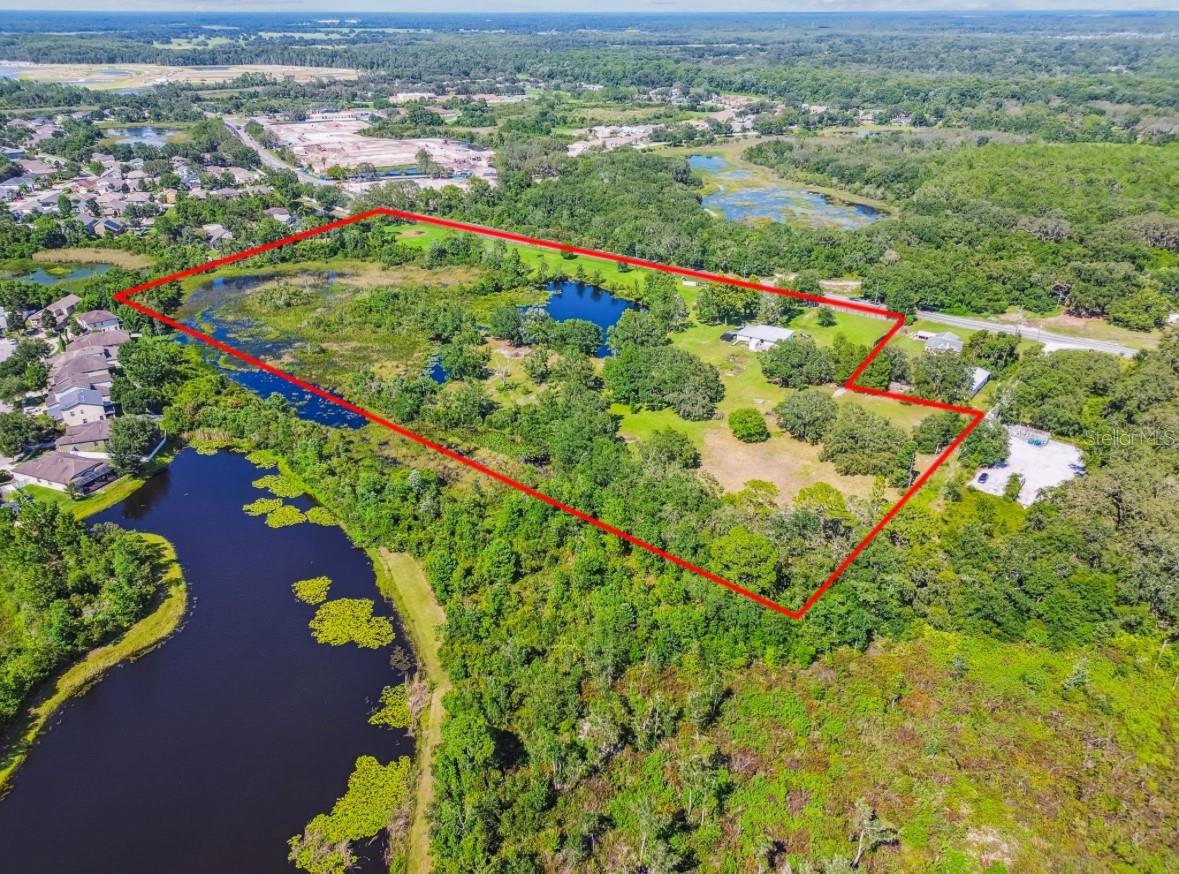 12317 & 12321 Shady Hills Road in Spring Hill, Florida offers 17 acres in one of the state’s fastest-growing areas. The property features 8 acres of uplands and 9 acres of wetlands, with over 1,000 feet of frontage on Shady Hills Road. Conveniently located just one mile from the Veterans Expressway and approximately 2,400 feet from State Road 52, this site offers excellent accessibility and exposure.
Designated as MU (Mixed Use) in the Pasco County Comprehensive Plan, the property supports potential rezoning to I-1, Commercial General, PO (Professional Office), or multifamily. The expansive 1,019 feet of road frontage allows for multiple access points and exceptional visibility.
The site includes a recently renovated 1930s home, a private lake, and a detached garage, adding both charm and functional versatility. Dimensions are approximately 1,019 feet along Shady Hills Road, 637 feet on the eastern boundary, and 1,188 feet on the western boundary.