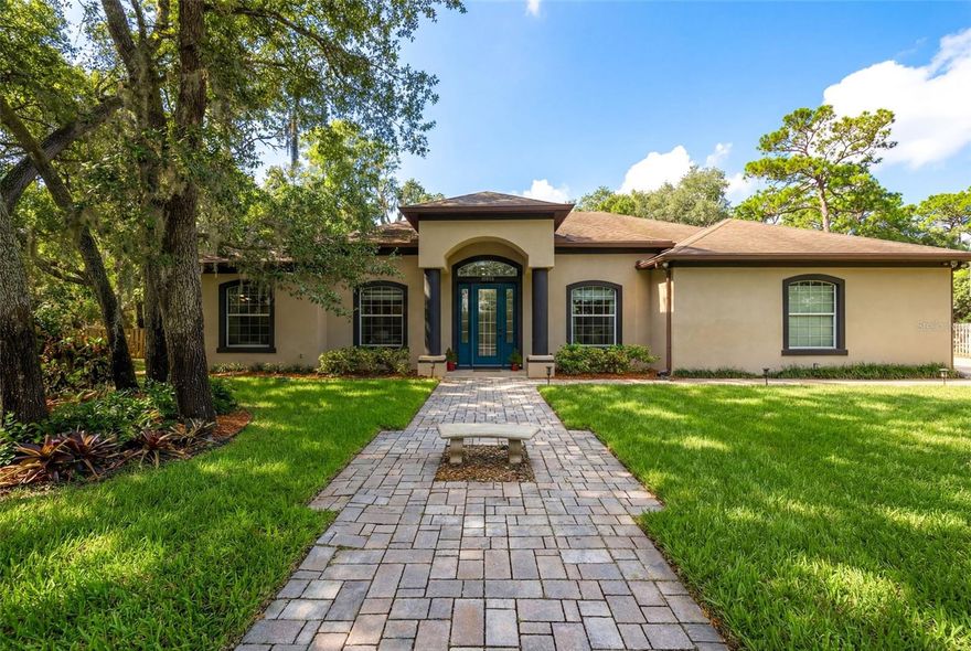 One or more photo(s) has been virtually staged. This multigenerational property sits on over ½ acre with no HOA. Nestled beneath mature oak trees, this single-story home offers 5 bedrooms and 4 bathrooms, blending traditional character with modern, resort-style features. Inside, you’ll find 12-foot ceilings, spacious light-filled living areas, and a split floor plan that provides both comfort and privacy. The primary suite serves as a private retreat, featuring two walk-in closets, an oversized bedroom, and a spa-style bathroom with a jetted soaking tub and generous layout. Each bedroom includes 10-foot ceilings, enhancing the open feel throughout the home. Triple glass doors lead to an outdoor living space designed for entertaining, including a screened-in patio of over 400 square feet with 12-foot ceilings, a pool and hot tub, and a fully equipped outdoor kitchen complete with its own bathroom and shower. With no HOA restrictions, the property offers flexibility for various uses. The outdoor shed provides potential for conversion into an ADU or detached mother-in-law suite, making it well suited for multigenerational living. Conveniently located near shopping, dining, and top-rated schools, this home offers space, versatility, and a desirable setting. Schedule your showing to explore the possibilities.