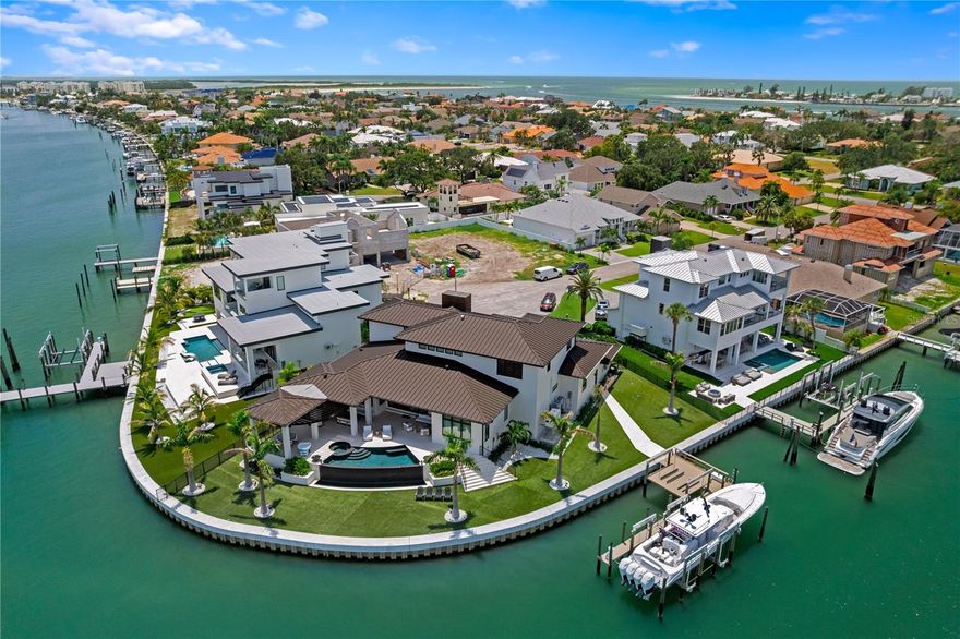This custom luxury home, completed in 2023, exemplifies exceptional coastal living and architectural excellence, set on 200 feet of waterfront with seamless access to open Gulf waters - a true haven for boating enthusiasts.   • DESIGN: Created by the award-winning Sire Design team, known from Netflix’s Designing Miami and HGTV’s Divided by Design, the home was thoughtfully designed for indoor-outdoor flow, everyday comfort, and timeless appeal.   • SMARTLY BUILT: Elevated construction, impact-resistant windows, full-house generator, supported by a pilings and stem wall foundation for enhanced structural integrity.   • LIVING SPACE: 5,251 square feet of air-conditioned space with 5 bedrooms, 6 full and 1 half bath, a loft, elevator, and two-2-car garages - all anchored by a dramatic 24-foot foyer with a custom pivot door.   • HOME AUTOMATION: A full Savant system manages audio-visual, lighting, security, window treatments, televisions, and music - delivering seamless, effortless everyday living through a centralized platform.   • INTERIOR FINISHES: Oak Plank Flooring, Avocatus quartzite, Van Gogh onyx, walnut accents, CLE tile, Atelier de Troupe lighting, and Waterworks fixtures add warmth, character, and quality throughout.   • OUTDOOR LIVING: A negative-edge heated pool with spillover spa, covered lounge area, and artificial turf create a low-maintenance outdoor retreat perfect for relaxing or entertaining.   • DOCK & BOATING: A custom dock completed in 2022 includes a 40,000-pound lift for a 52-foot boat, 2 JetSki lifts, and a seawall completed in 2020. There is ample space to position a larger yacht as well.    • SETTING: Situated on a beautiful street in a peaceful waterfront setting, the home offers effortless access to the water, with the dock placed to the side to preserve open views. Located just minutes from beaches, parks, dining, shopping, and airports, this home offers a lifestyle defined by thoughtful design, premium finishes, and convenience - both on and off the water. Come experience the level of quality, comfort, and design that truly sets this home apart.