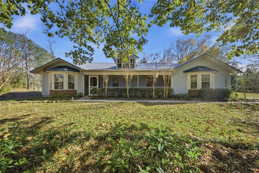 Country living just minutes from town! This well-appointed 4-bedroom, 2-bath Hartley Brothers home sits on 5 beautiful acres, offering the perfect blend of privacy, charm, and convenience—only a short drive to Town of Tioga and Jonesville.  Tucked away at the end of the road and surrounded by majestic old-growth oak trees, this property is a nature lover’s dream with ample room to expand. The grounds feature mature lemon trees, a garden area, a barn plumbed for running water, fenced chicken coop, small greenhouse, a cozy screened gazebo with swing, and a separate custom-built garage ideal for storage, a camper, or a large enclosed workshop. Two tractors currently housed in the barn convey with the property, making this an exceptional opportunity for hobby farming, gardening, or land maintenance.  The rear portion of the property remains untouched, offering plenty of space for a future stable, additional pasture, or equestrian use, while still preserving privacy and natural beauty.   Move-in ready and designed for both active living and peaceful retreat, the home welcomes you with a private living room featuring a beautiful brick, wood-burning fireplace and a bay window overlooking a stunning oak tree out front. The spacious dining room offers a large picture window where natural light pours in while you enjoy views of cardinals and wildlife outdoors.  The family room, located toward the back of the home, overlooks the side porch and gazebo and features abundant windows—providing serene views from every seat. The well-appointed kitchen includes custom wood cabinetry, generous cabinet space, and an oversized walk-in pantry complete with a second full-size freezer.  Each bedroom is spacious with ample closet space and a unique view of the property. The private primary suite is quietly tucked away at the rear of the home and features a large bathroom and walk-in closet. The oversized two-car garage provides excellent storage, and the laundry room impresses with abundant cabinetry and a large window that fills the space with natural light.  A rare opportunity to enjoy true country living on 5 acres with equestrian potential—while still being just minutes from town amenities. This home truly offers the best of both worlds.