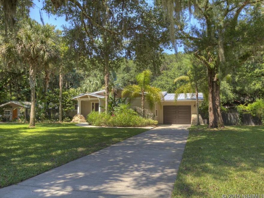 This lovely home is situated on almost an acre of land with native and fruit trees surrounded by a tropical oasis.  It is centrally located in New Smyrna Beach with easy access to shopping, restaurants and schools. This is an outstanding example of craftsmanship, luxury and comfort. This no- expense spared home has been, meticulously designed and seamlessly fuses indoor/outdoor living spaces into one (26' x16' x 10' tall Pergola with landscape paver's separating main house and guest house). It is truly a must see, complimented by high end accents such as bamboo wood flooring, plantation shutters, upgraded lighting, fans and sun tunnels. The kitchen is appointed with upgraded cabinets, granite counter-tops and SS Energy Star stainless steel appliances. It is well-insulated with Demilec Agribalance Foam, up to R-50 in conditioned attic spaces, lifetime metal roof on both main house and guest house, a one car garage detached shed, hurricane shutters, low E Glass windows. Some additional features include full RV hookups, whole house fan, commercial grade gutters on guest house, and custom wood fence. The in-law suite as been recently renovated. ;Water: City