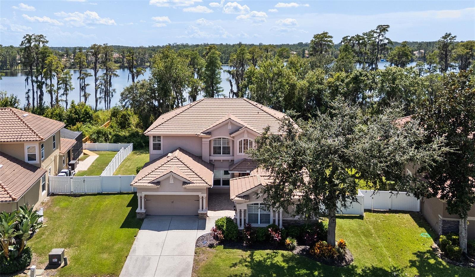 One or more photo(s) has been virtually staged. Luxurious LAKEFRONT Home in Water's Edge ... a gated community in Pasco County! This 4 bedroom, 3 bath has an office, bonus room, loft/study, 3-car garage with heated salt water screened pool, and DOCK. Floor plan is very flexible so if you need additional bedrooms no problem. As you drive up notice the front pavered courtyard & tile roof. 15 windows recently replaced with hurricane impact windows. The majority of home features beautiful wood, tile, & laminate flooring. There is a bedroom and full bath downstairs ... conveniently located to living room and downstairs study. Could easily be converted to an awesome IN-LAW SUITE! The kitchen has been remodeled with raised-panel wood cabinets with crown molding, beautiful light thick granite counters, large island, stainless appliances (convection oven & air fryer), and huge walk-in pantry. The majority of the appliances have been replaced. The adjacent dining area features a custom table with granite counter and overlooks the pool & lake. The kitchen overlooks the family room which also overlooks the lake! Also downstairs is a study/library and formal living & dining rooms. Woods stairs lead to landing & wood hallway. There are 3 bedrooms, a bonus/media room, and study/versatile room (or additional bedroom) upstairs. The primary suite features wood floors, new wood-like tile in bath, 2 walk-in closets, garden bath with walk-in shower, large vanity with dual sinks, and window seat. The bonus/media room has French door entry & surround sound speakers. The upstairs study also has wood flooring. Sliding door off the family room & dinette lead to a large covered lanai with pavered pool deck. The pool was resurfaced in 2019. The wood walkway leads to a lakefront dock with additional floating dock for easy access for boat tie up. Decking has recently been replaced. Both central heat and air units were replaced in 2019. Home is located on West Moon Lake which is 53 acres. Lakefront owners also enjoy PRIVATE ACCESS to the lake for boats, jet skis, kayaking, fishing, and more. Waters Edge also has a RESORT style community center with workout equipment, community pool, basketball, park, & community dock. Community has great access to the Suncoast Parkway/Veterans Express making it an easy commute to Tampa, Tampa International Airport, and more. Easy commute to the Trinity area for restaurants, hospital, shopping, and more! Priced to Sell ... quick occupancy available.