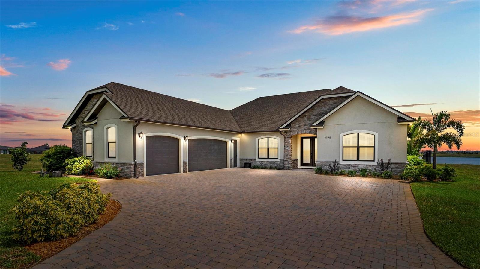 Welcome to this exquisite 4-bedroom, 3.5-bathroom custom-built masterpiece in the exclusive Water Ridge community, where elegance meets modern convenience. This vacant home, designed for discerning buyers, showcases impeccable craftsmanship with crown molding throughout, shaker window treatments, elegant tile flooring throughout, and a bright, airy grand foyer. The gourmet kitchen is a chef’s dream, featuring elegant wood cabinetry, a large breakfast island, stainless steel appliances, a cook top, range hood, under-cabinet wine cooler and large walk in pantry. The kitchen flows seamlessly into a cozy dining area, perfect for gatherings. The primary suite is a luxurious haven with a tray ceiling, crown molding, a spacious walk-in closet, and a spa-inspired en-suite boasting dual vanities, a soaking tub, and a walk-in shower. Bedrooms 2 and 3 share a convenient Jack-and-Jill bathroom with dual sinks and a walk-in shower, while Bedroom 4 features a private bathroom and a spacious walk-in closet. The utility room offers ample storage space, generous countertop space, and a sink, enhancing functionality. A practical mud room and a secure safe room provide added convenience and peace of mind. Additional highlights include a tankless water heater, solar panels (owned, with an $18 monthly bill), an attic room for extra storage, security cameras, and an outside pest control system. The fenced rear yard offers privacy, with stunning lake views from the screened infinity pool and hot tub, both heated for year-round enjoyment, complemented by irrigation from a well. This residence includes a two-car garage and a separate one-car garage for vehicles, storage, or hobbies. The beautifully landscaped backyard features a private patio, perfect for entertaining. Water Ridge residents enjoy resort-style amenities, including multiple sparkling pools, tennis and pickleball courts, a state-of-the-art fitness center, a luxurious clubhouse, scenic walking trails, private boat launches on Lake Van and Lake Alfred, on-site boat storage, and access to three serene lakes for boating, fishing, and water activities. Conveniently located between Tampa and Orlando, this move-in-ready home offers easy access to attractions, shopping, dining, and international airports, while providing a tranquil retreat. Schedule your private tour today to experience this lakeview gem!